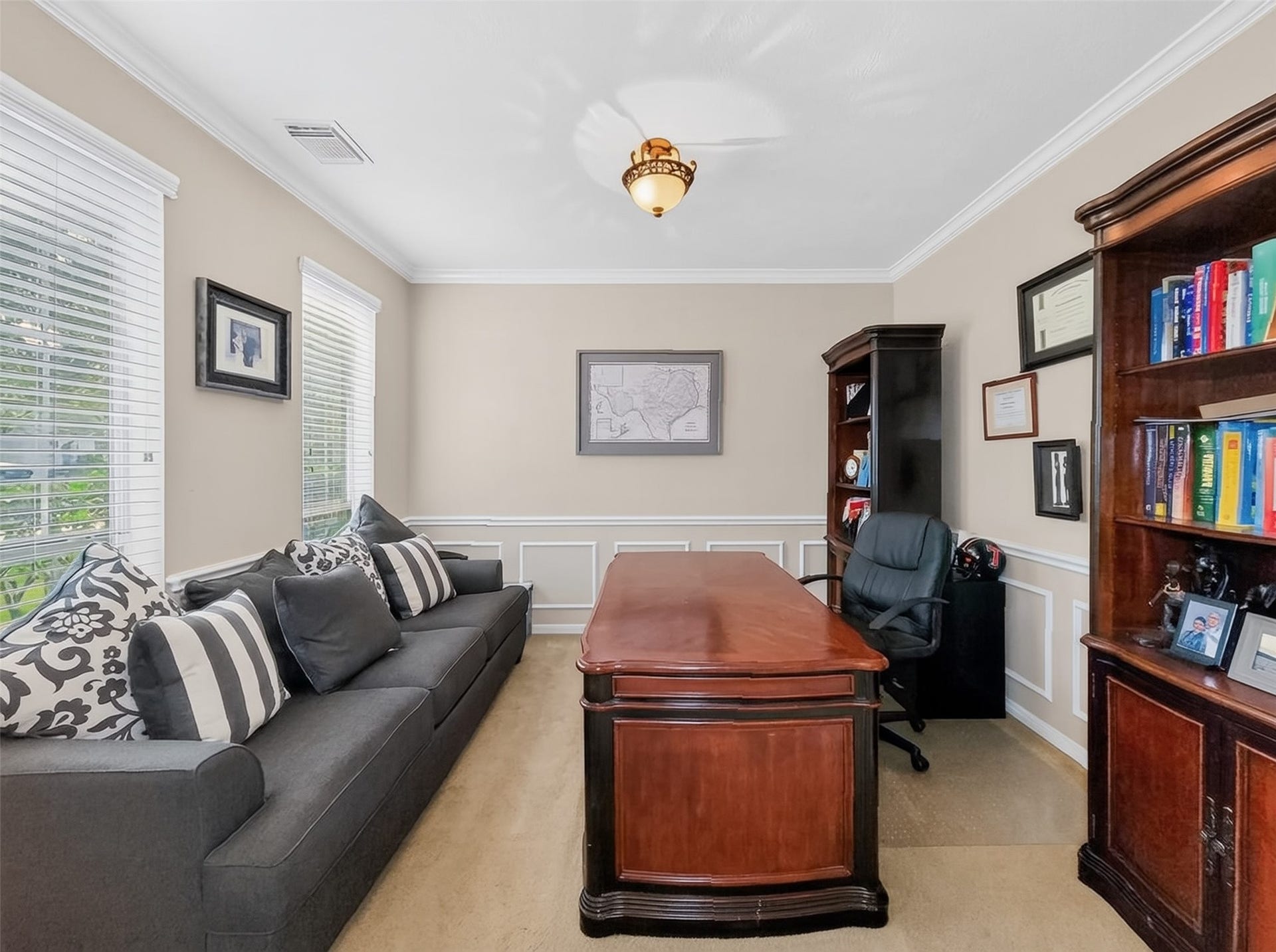 2006 Linden Cove Court, Katy, TX 77494 Elegant home office with rich wood furnishings, built-in bookshelves, and ample natural light from large windows, creating a sophisticated and inviting workspace.