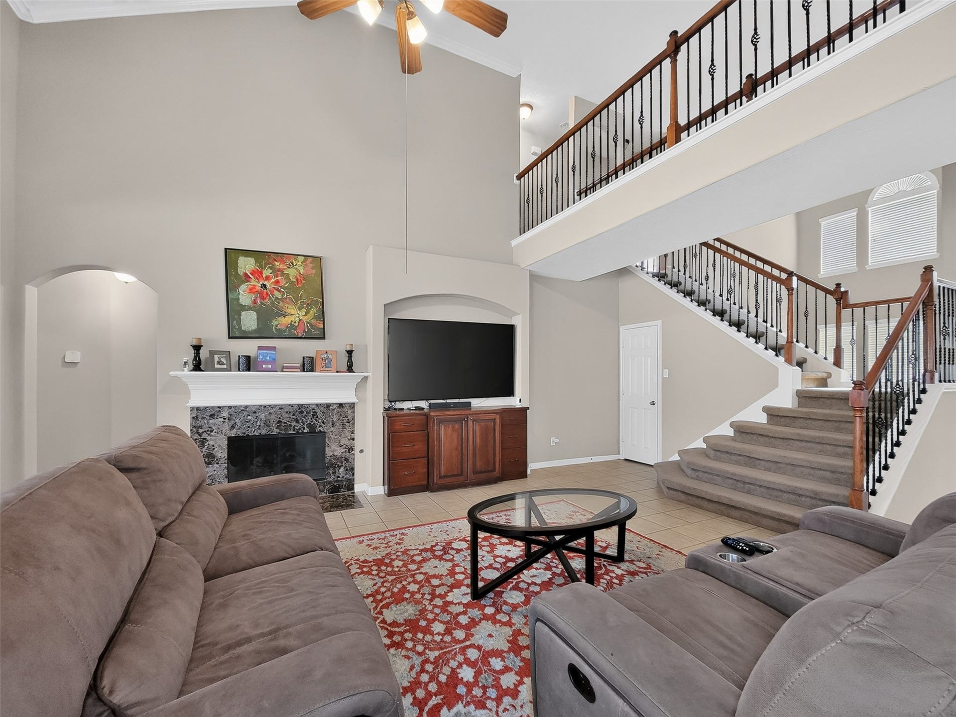 2006 Linden Cove Court, Katy, TX 77494 Spacious living area featuring a cozy fireplace, vaulted ceilings, and an elegant staircase, perfect for relaxation and entertaining.