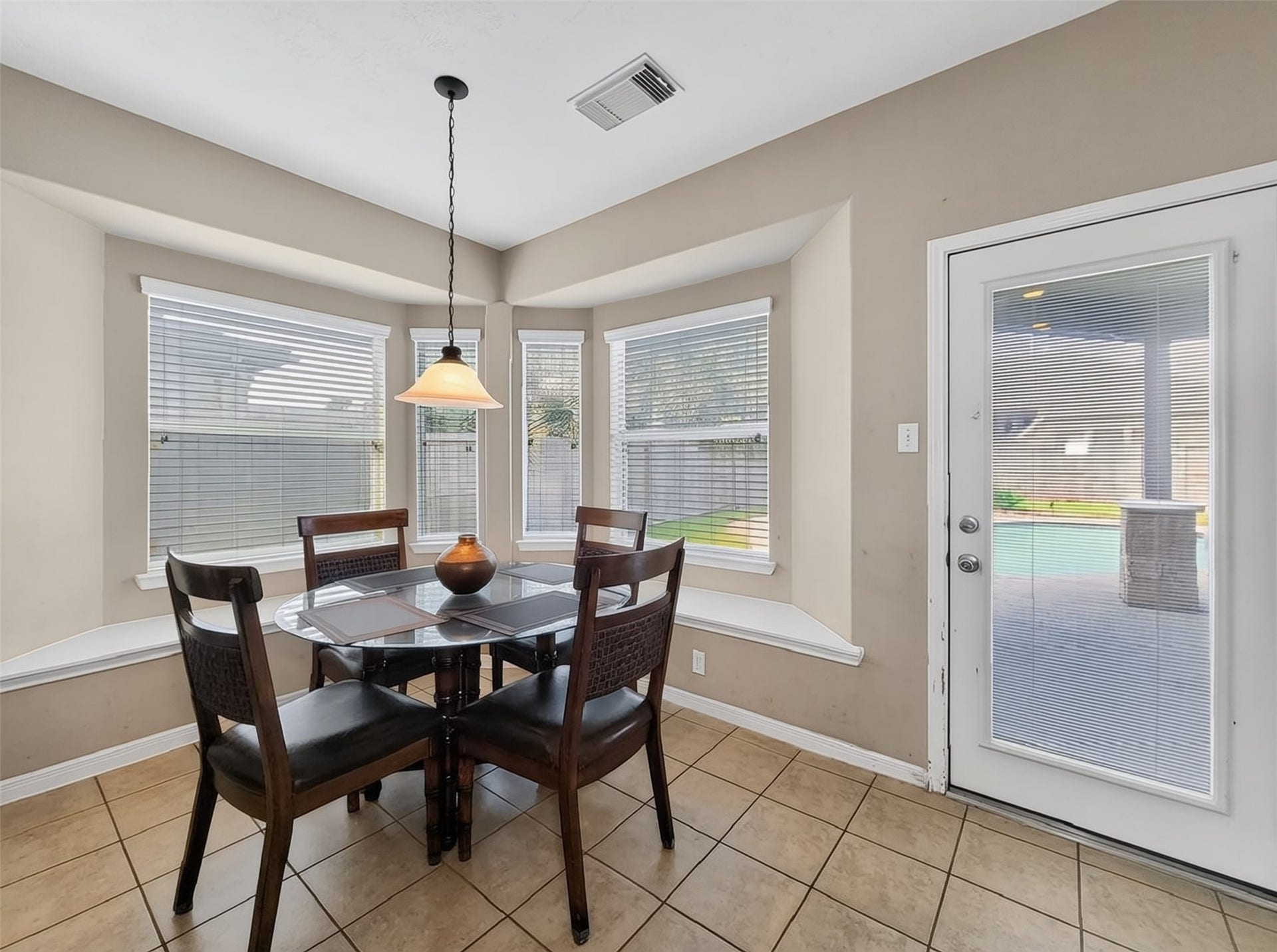 2006 Linden Cove Court, Katy, TX 77494 Bright breakfast nook with large bay windows, tile flooring, and a door leading to the backyard, perfect for enjoying morning light and easy outdoor access.