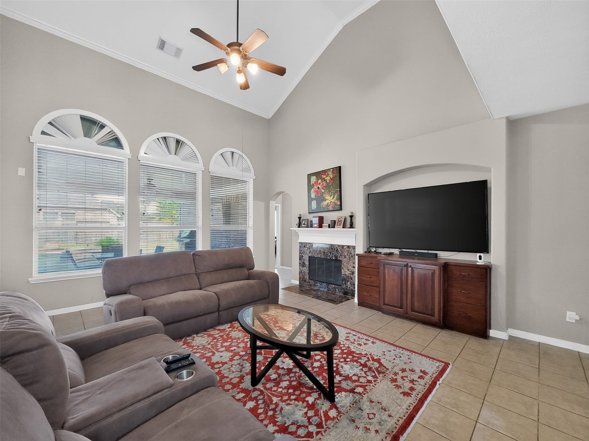 2006 Linden Cove Court, Katy, TX 77494 Spacious living room with high ceilings, abundant natural light from arched windows, and a cozy fireplace.