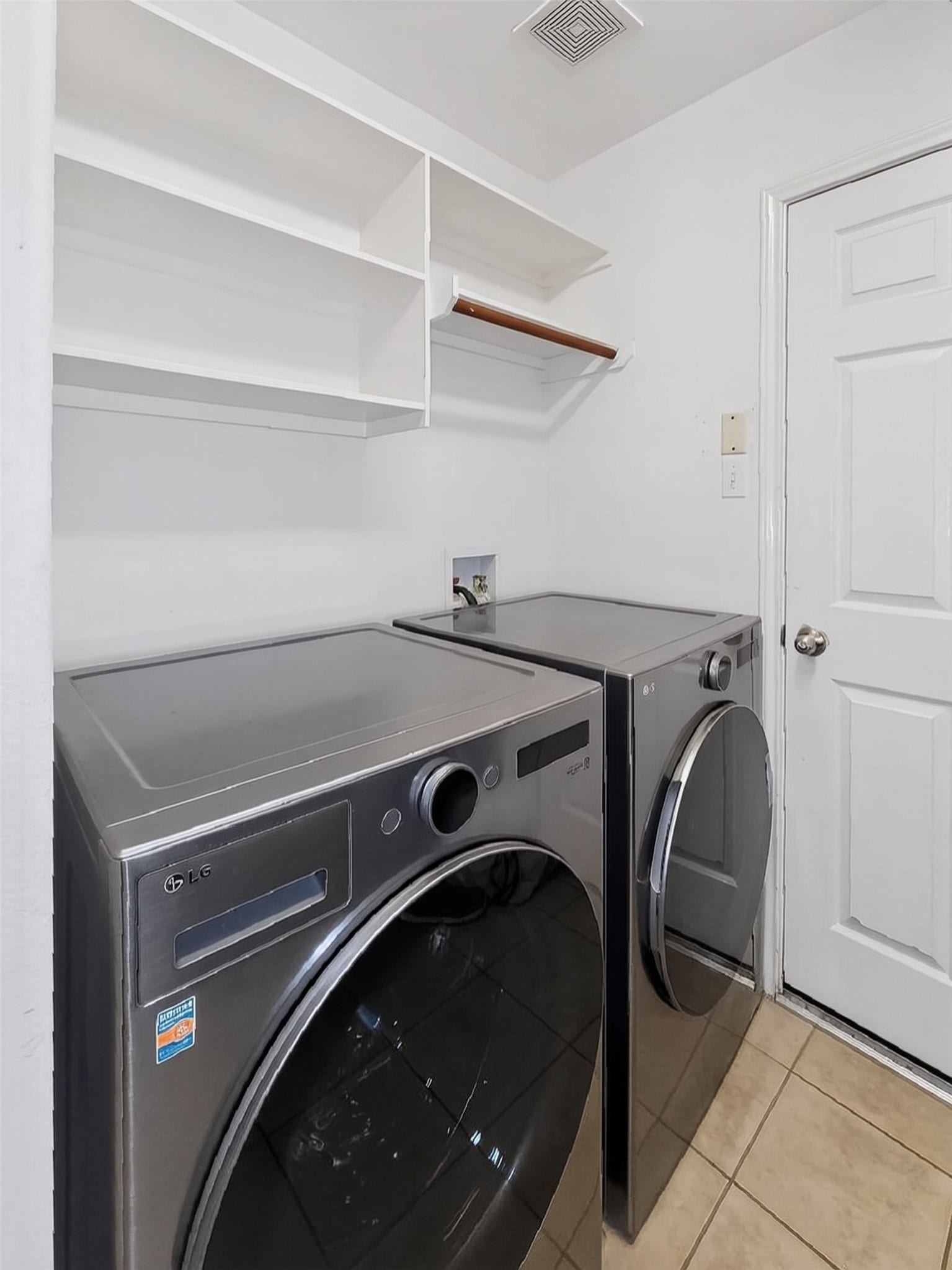 2006 Linden Cove Court, Katy, TX 77494 Efficient laundry room featuring modern washer and dryer, ample shelving, and convenient storage solutions.
