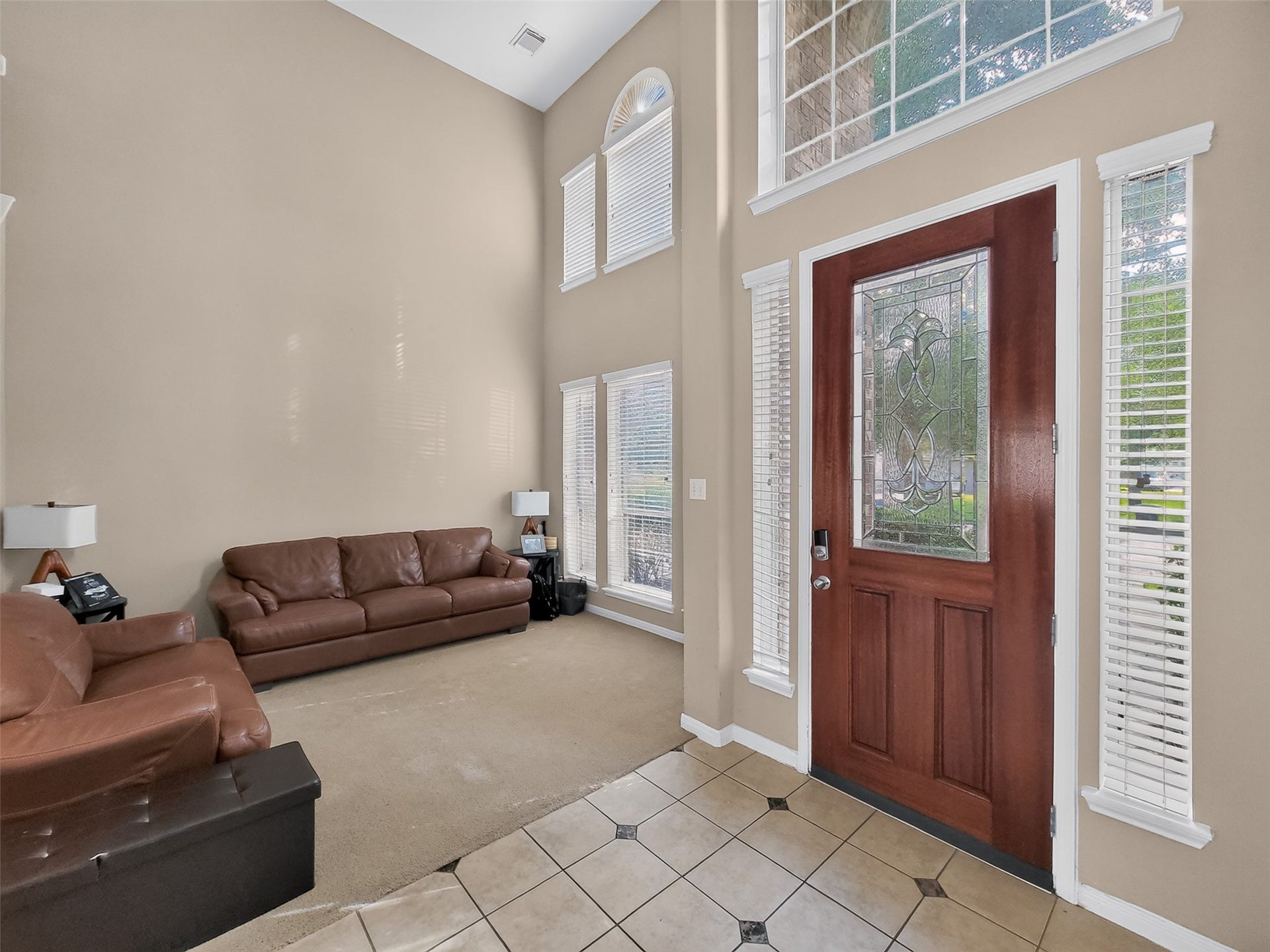 2006 Linden Cove Court, Katy, TX 77494 Grand entrance featuring a beautifully crafted wooden door with intricate glass design, leading into a spacious living area with high ceilings and abundant natural light.