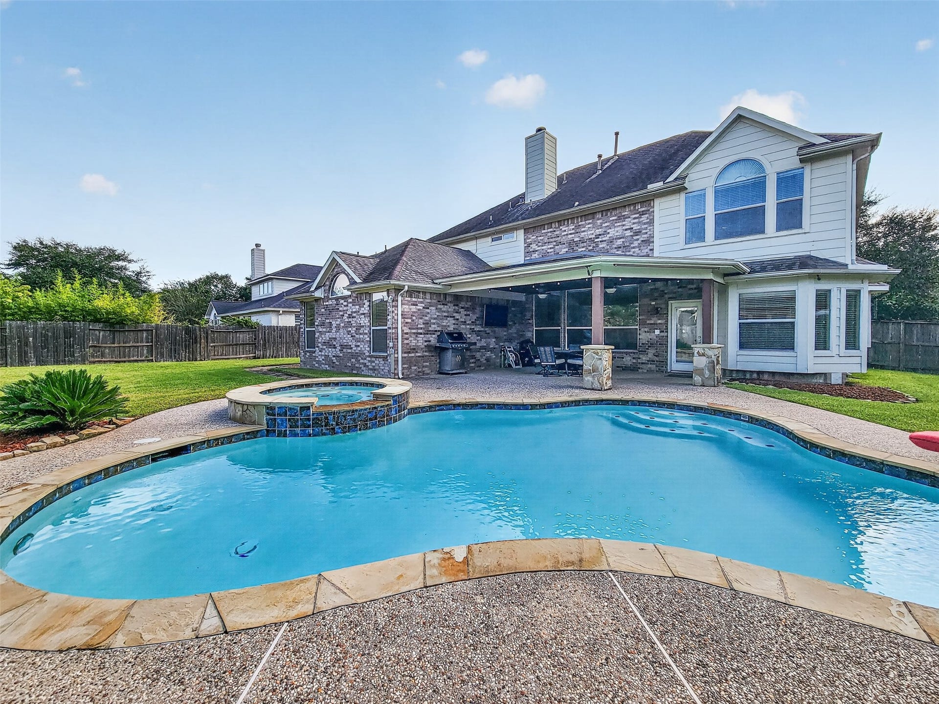 2006 Linden Cove Court, Katy, TX 77494 Dive into luxury with this stunning backyard featuring a sparkling pool and attached spa, perfect for relaxation and entertaining.