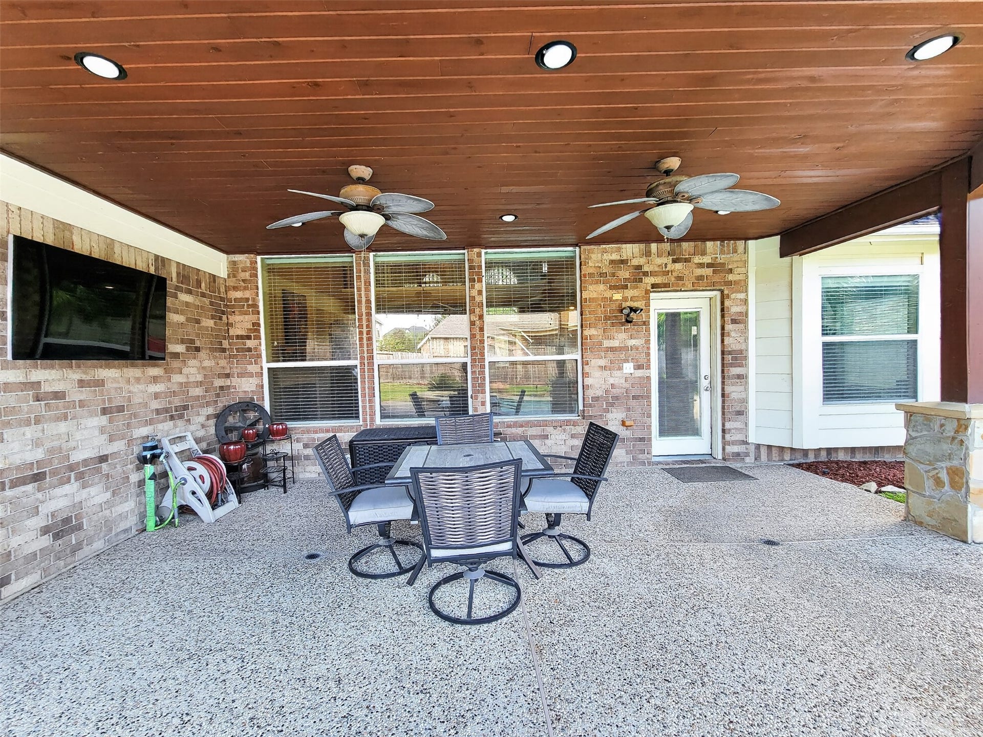 2006 Linden Cove Court, Katy, TX 77494 Spacious covered patio featuring a ceiling with recessed lighting and fans, perfect for outdoor dining and entertainment, complete with a mounted TV for relaxation.