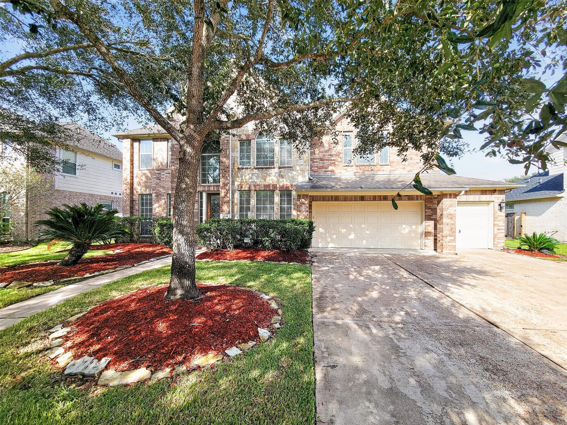 2006 Linden Cove Court, Katy, TX 77494 Charming two-story brick home with a spacious two-car garage, surrounded by mature trees and manicured landscaping, offering great curb appeal.