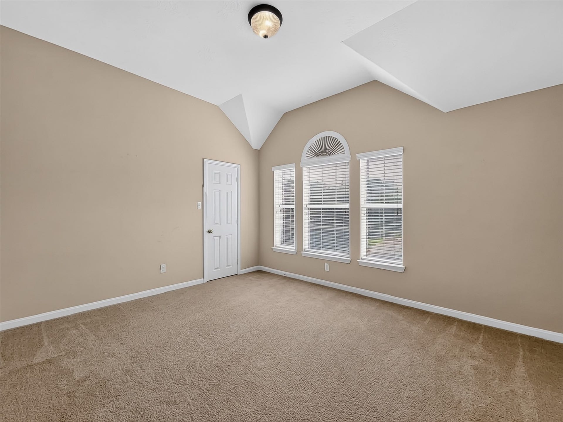 2006 Linden Cove Court, Katy, TX 77494 Spacious bedroom with vaulted ceilings, abundant natural light from large arched windows, and warm neutral tones.
