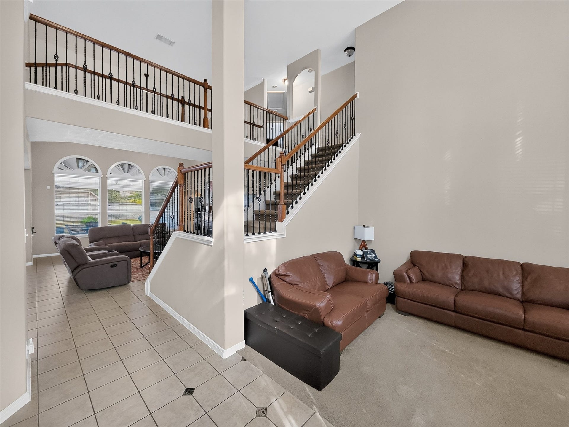 2006 Linden Cove Court, Katy, TX 77494 Spacious living area with high ceilings, elegant staircase, and abundant natural light from large arched windows, perfect for both relaxation and entertaining.