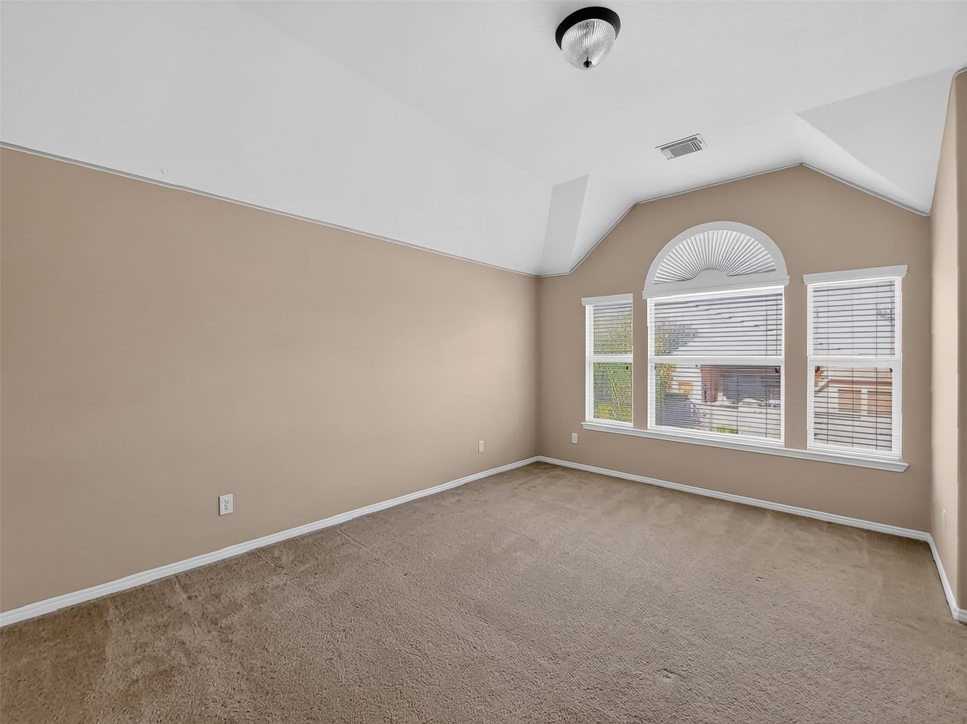 2006 Linden Cove Court, Katy, TX 77494 Spacious room with vaulted ceiling, featuring a large arched window that fills the space with natural light.
