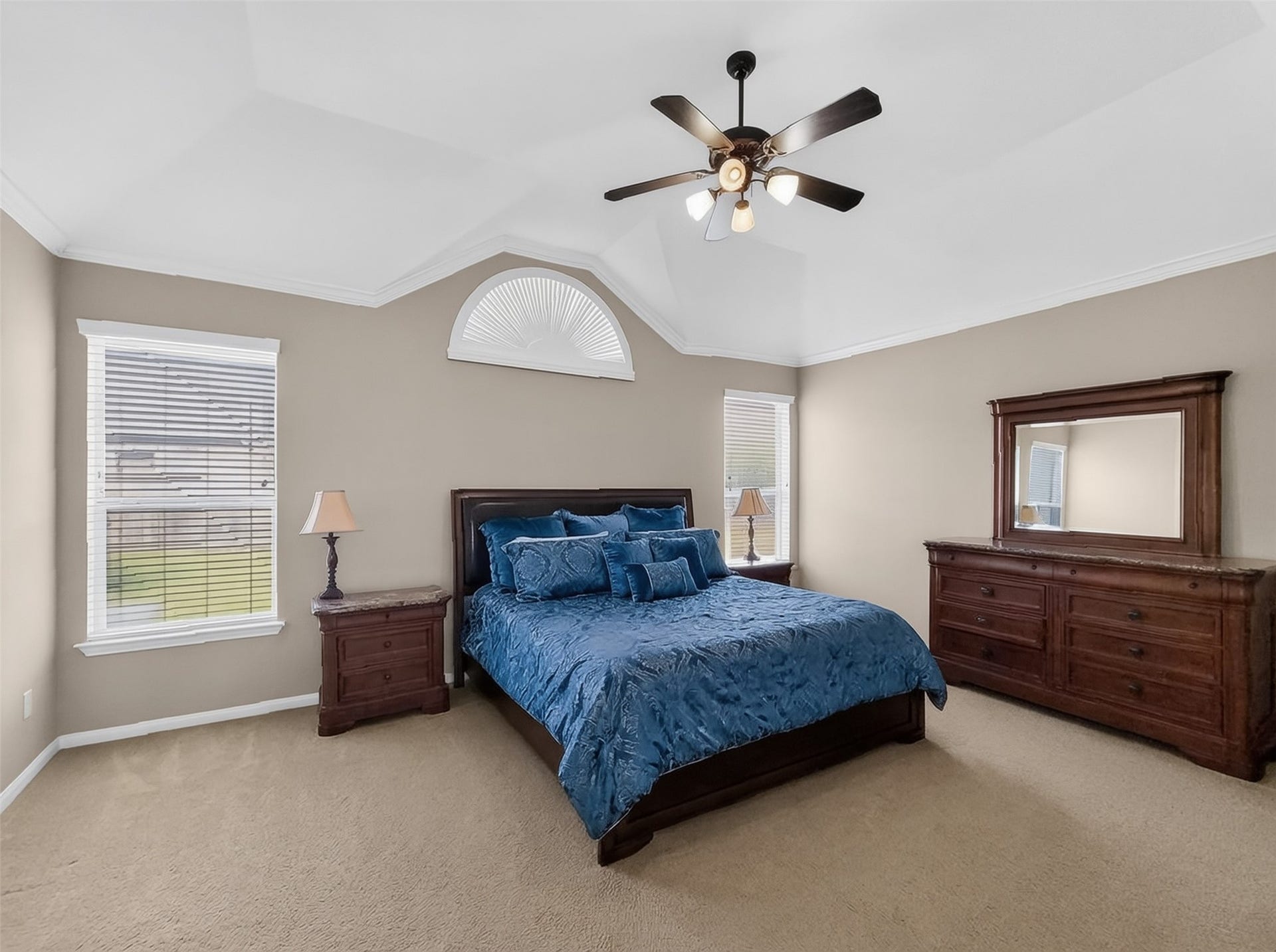 2006 Linden Cove Court, Katy, TX 77494 Spacious bedroom with elegant tray ceiling, abundant natural light, and rich wood furniture, creating a serene retreat.