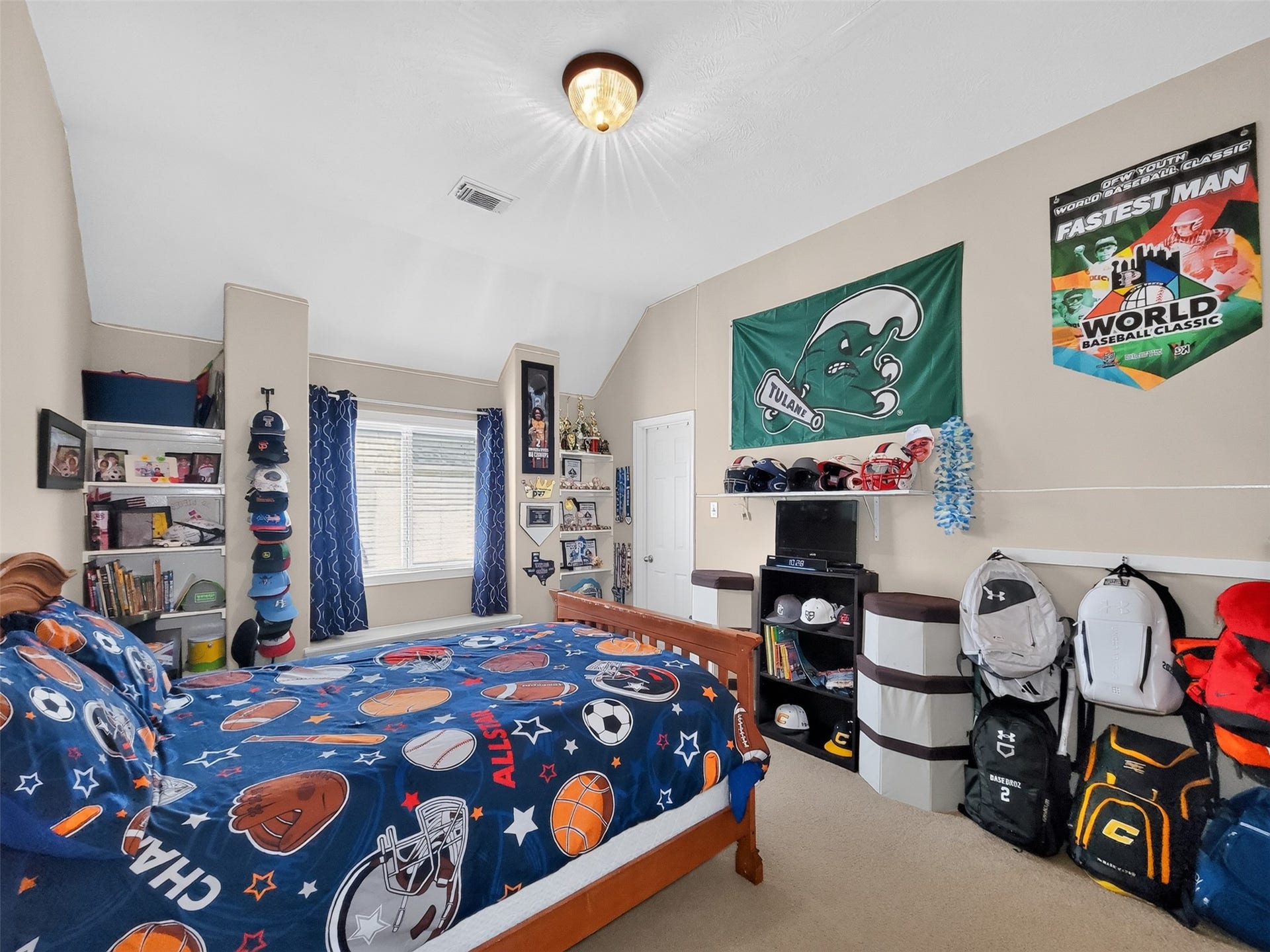 2006 Linden Cove Court, Katy, TX 77494 Bright and spacious bedroom with sports-themed decor, featuring a cozy bed, ample shelving for storage, and vibrant wall art, perfect for a young sports enthusiast.