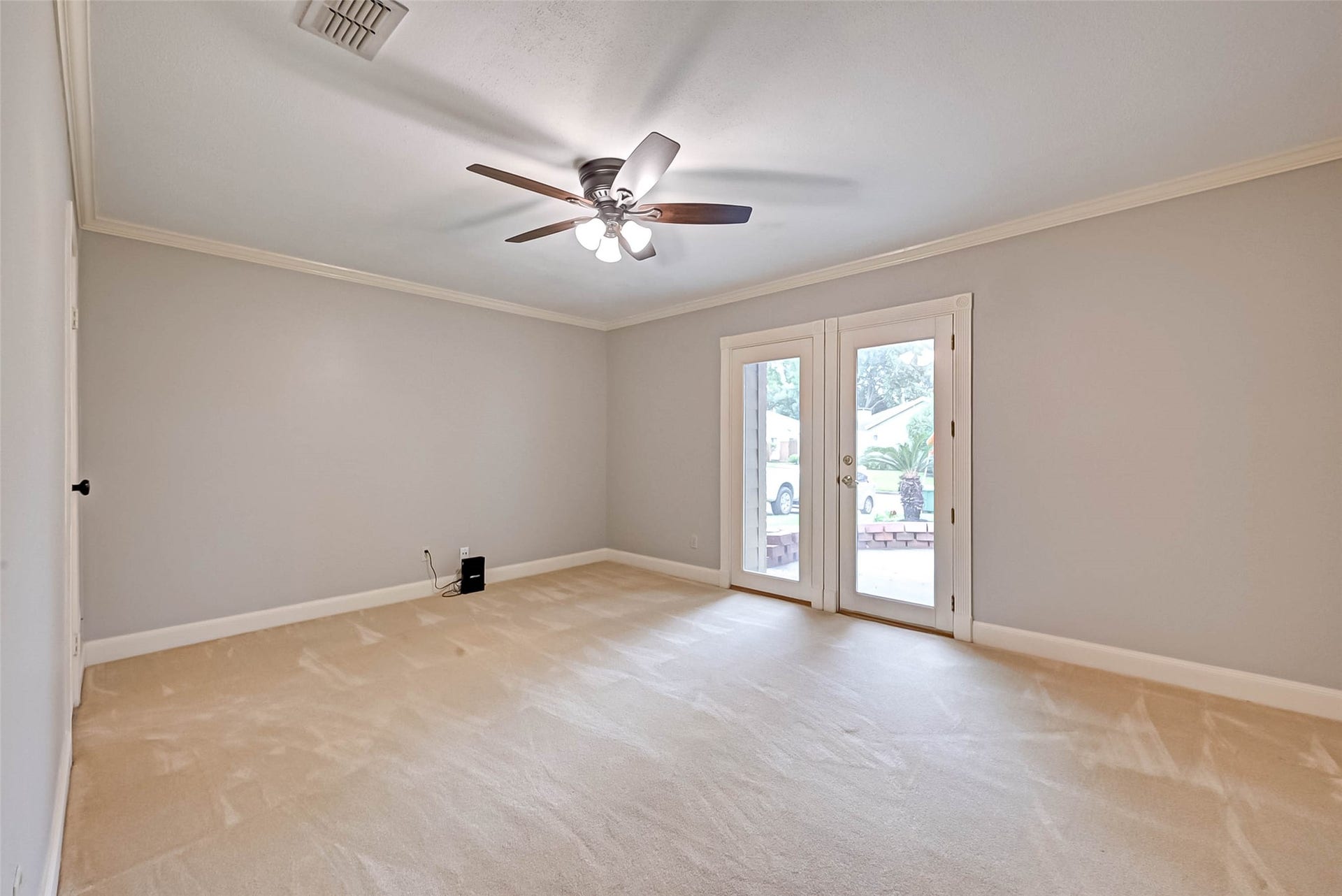 One guest bedroom with french doors leading to the outside.