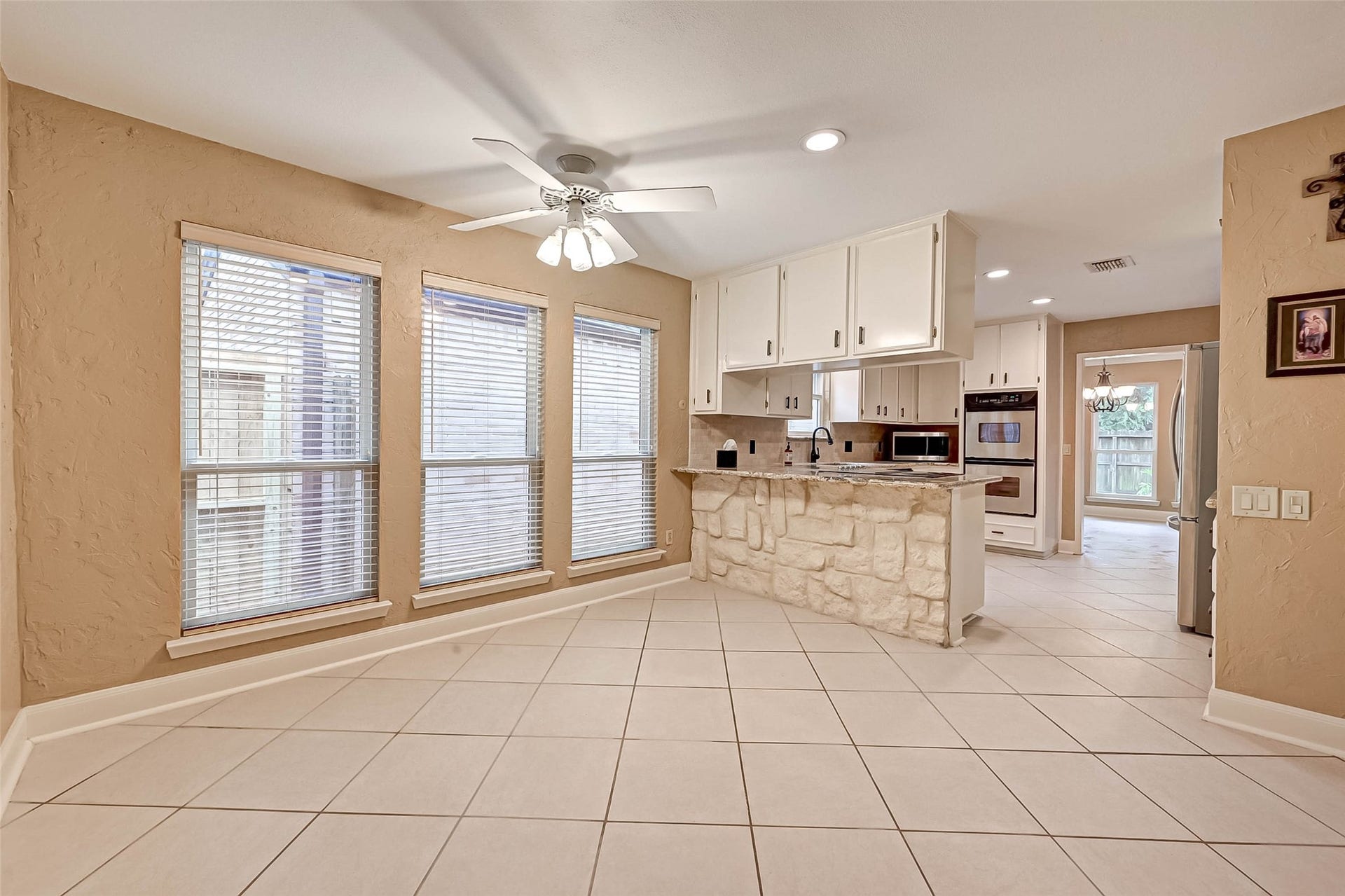 View of the lovely kitchen with stone accents as taken from the breakfast area.