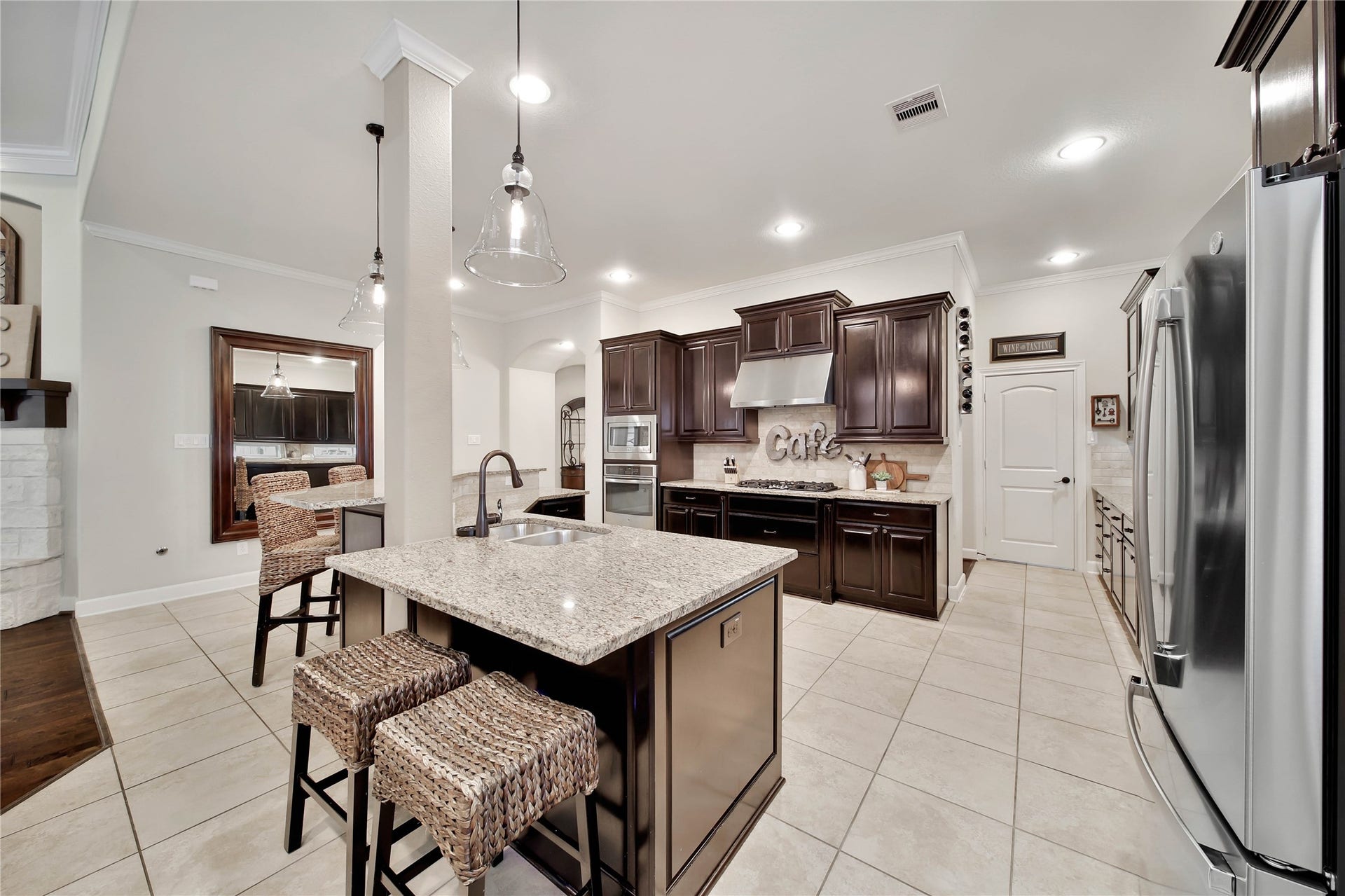 The kitchen offers both bar-height and counter-height islands, providing versatile spaces for everything from homework and casual meals to snacks and entertaining.