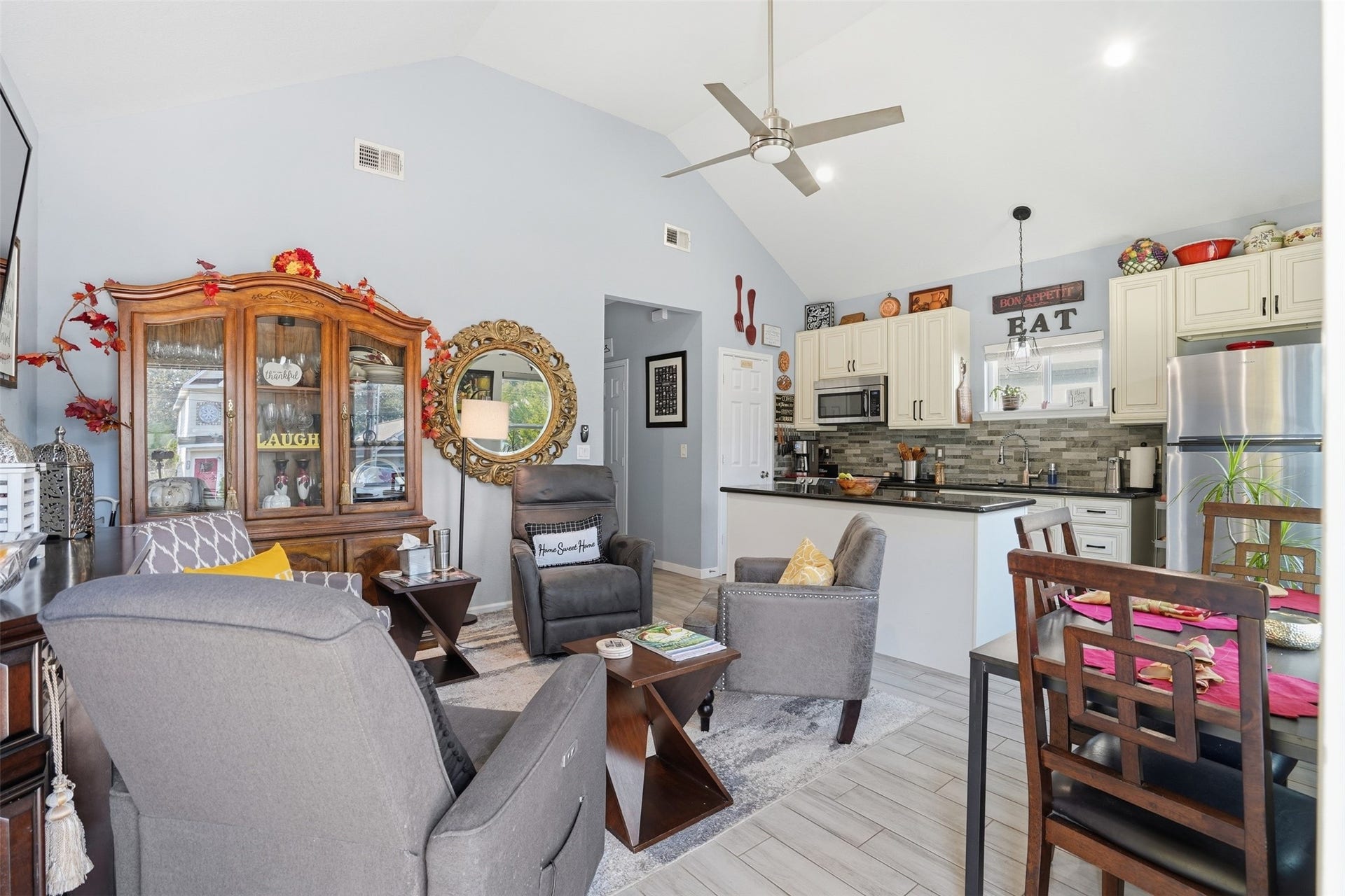 16740 Stonefield, Montgomery, TX 77316 Open-concept living area featuring vaulted ceilings, modern kitchen with stainless steel appliances, and cozy seating perfect for relaxation and entertaining.