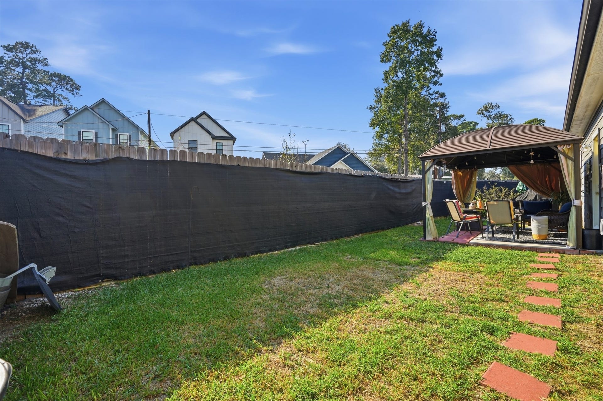 16740 Stonefield, Montgomery, TX 77316 Backyard retreat featuring a cozy gazebo with outdoor seating, perfect for relaxation and entertaining.