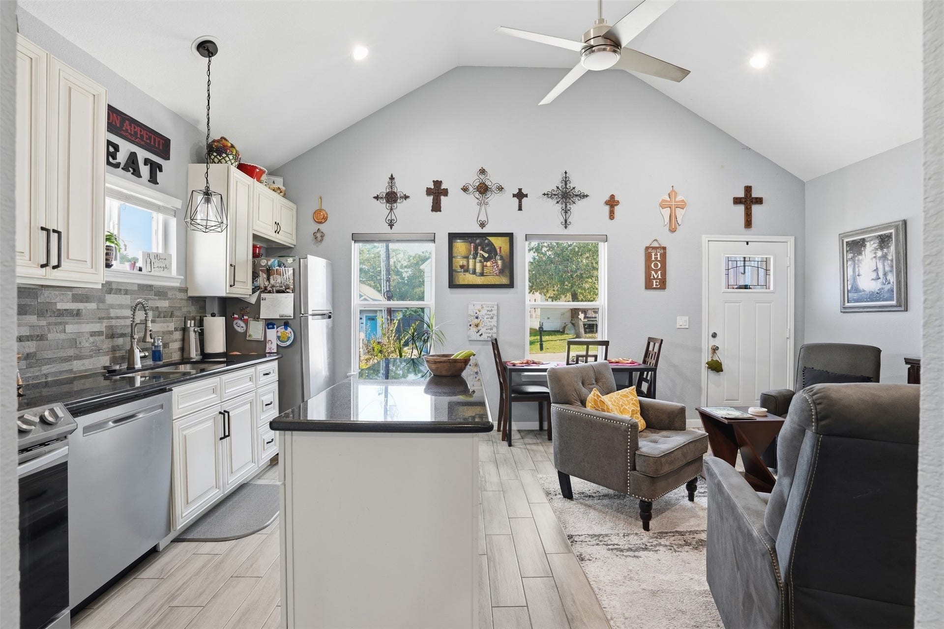 16740 Stonefield, Montgomery, TX 77316 Open-concept living space with vaulted ceilings, featuring a modern kitchen with stainless steel appliances and a cozy seating area.