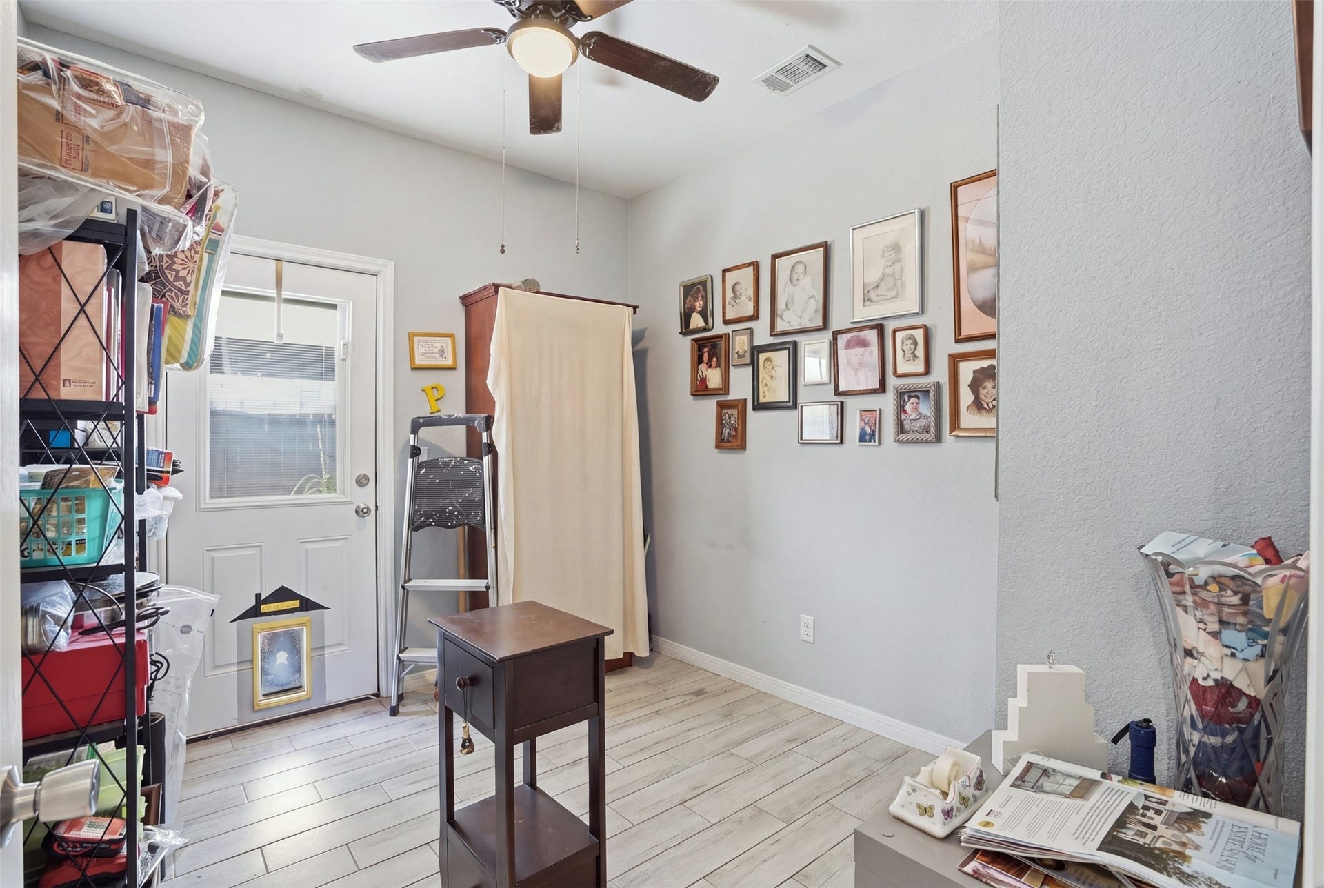 16740 Stonefield, Montgomery, TX 77316 Bedroom with light wood flooring, wall-mounted artwork, and ample storage space, featuring a ceiling fan and natural light from the back door.