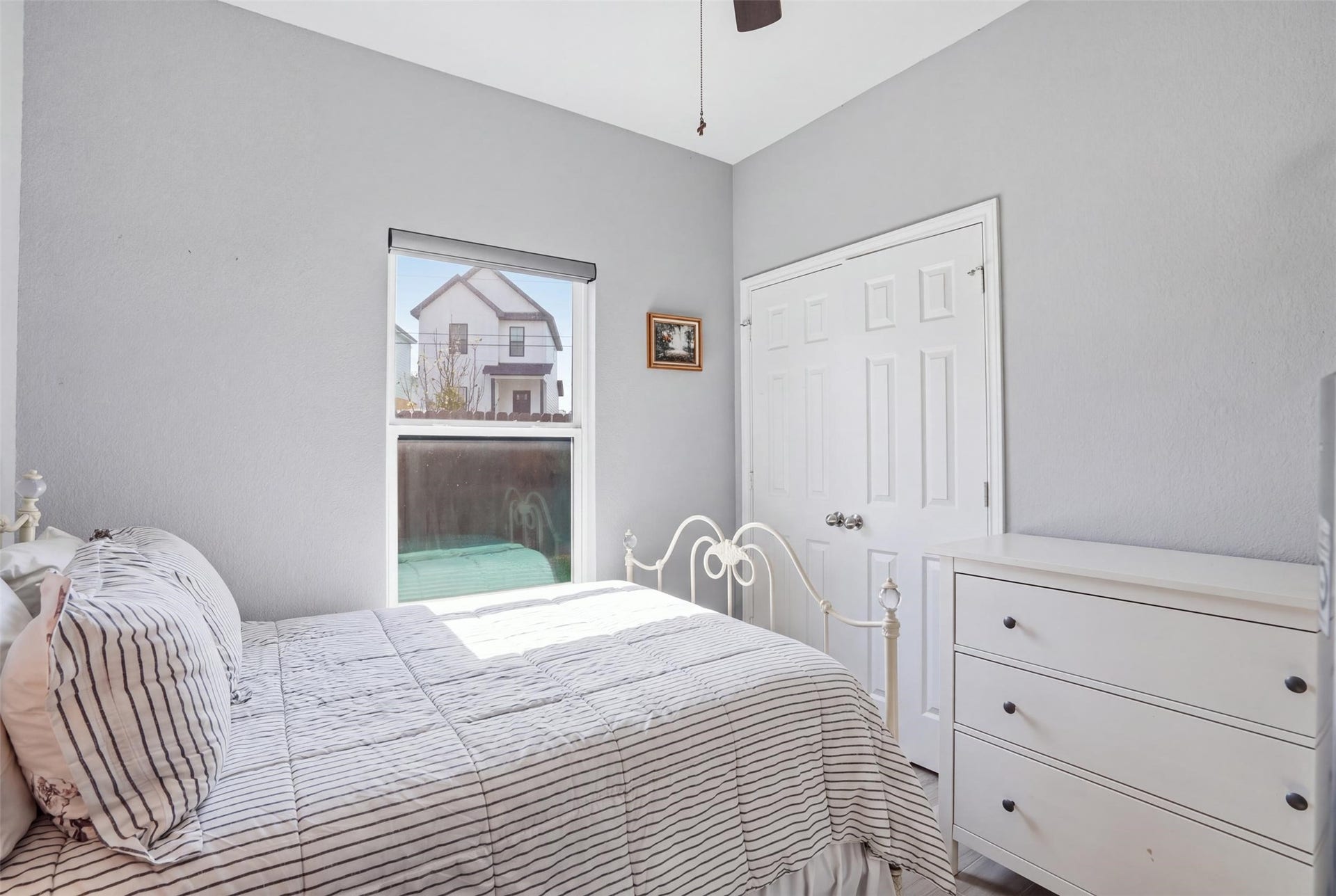 16740 Stonefield, Montgomery, TX 77316 Bedroom featuring soft gray walls, ample natural light, and a classic white bed frame, complemented by a sleek white dresser.