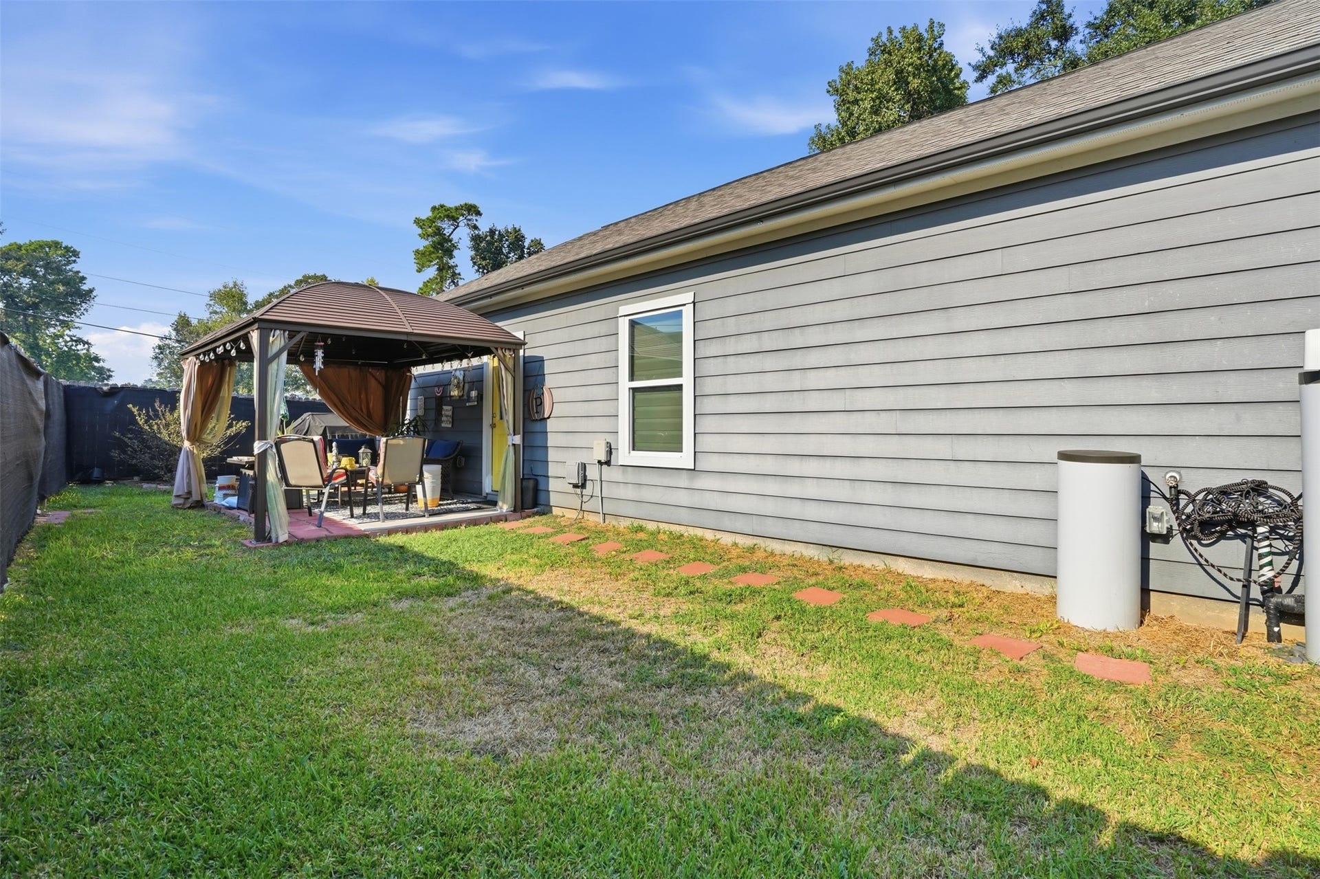 16740 Stonefield, Montgomery, TX 77316 Charming backyard retreat features a cozy gazebo perfect for outdoor entertaining, surrounded by lush greenery and a well-maintained lawn.