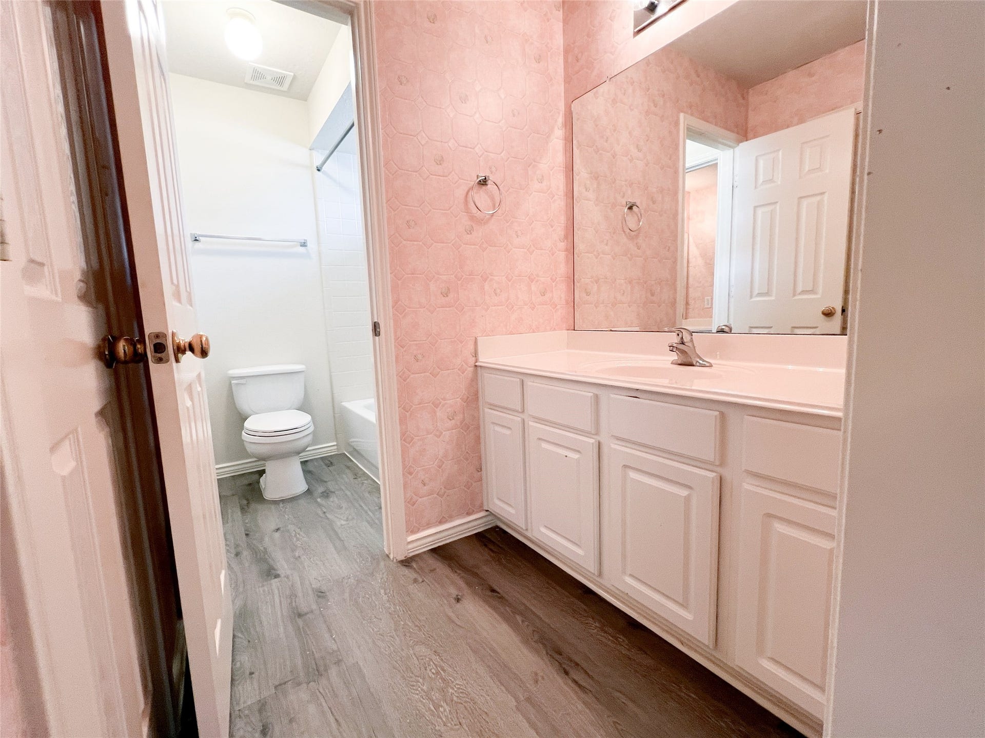 908 Azalea Pointe, League City, TX 77573 Charming second-floor bathroom featuring a spacious vanity, elegant wood flooring, and a bright, inviting ambiance.