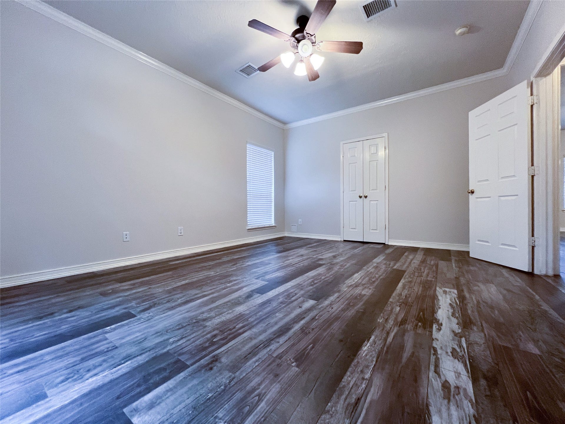 908 Azalea Pointe, League City, TX 77573 Spacious primary bedroom on the first floor featuring elegant flooring and abundant natural light, perfect for relaxation and convenience.