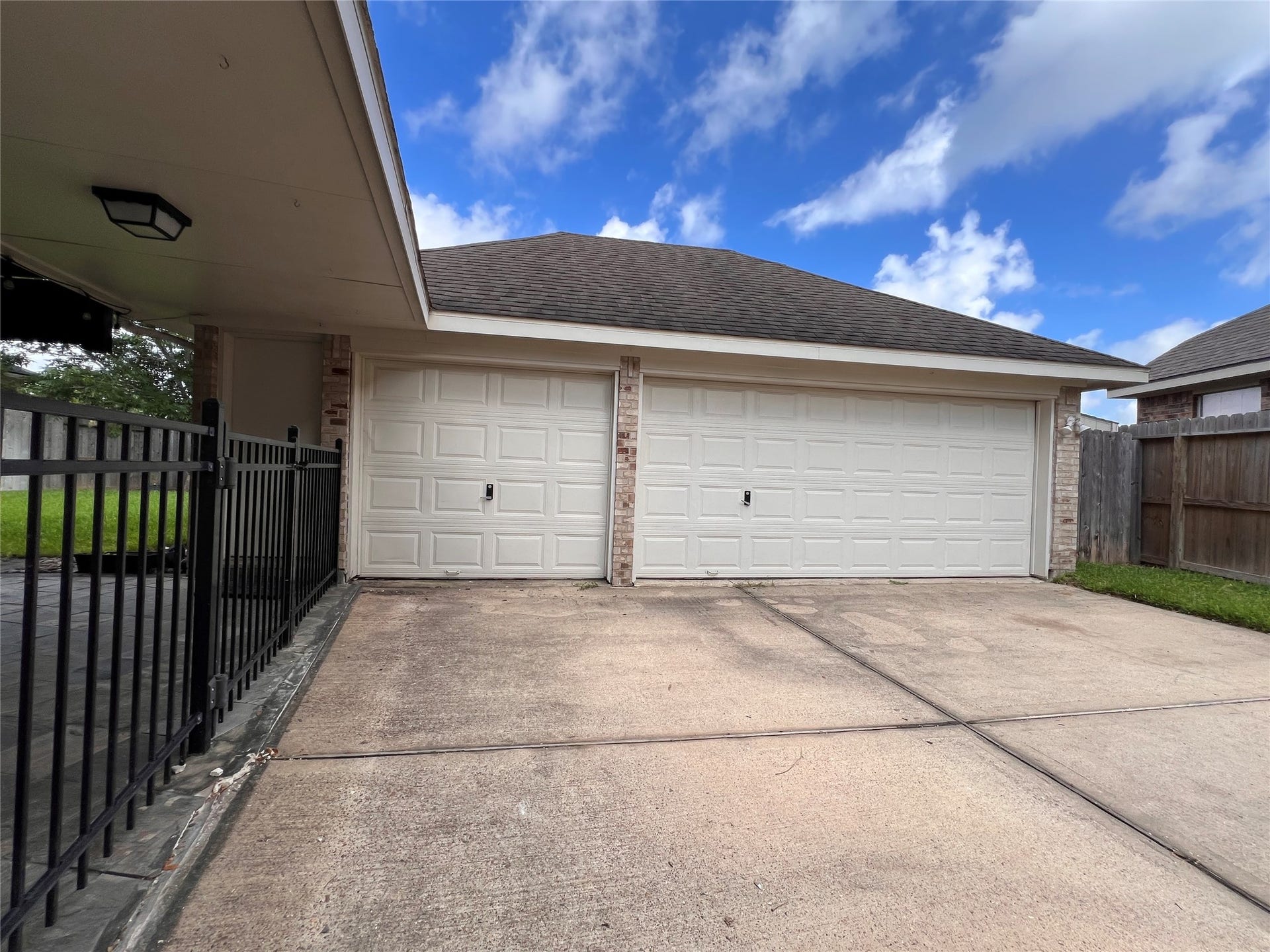 908 Azalea Pointe, League City, TX 77573 Spacious three-car garage with a wide driveway and secure fencing, ideal for convenient parking and storage.