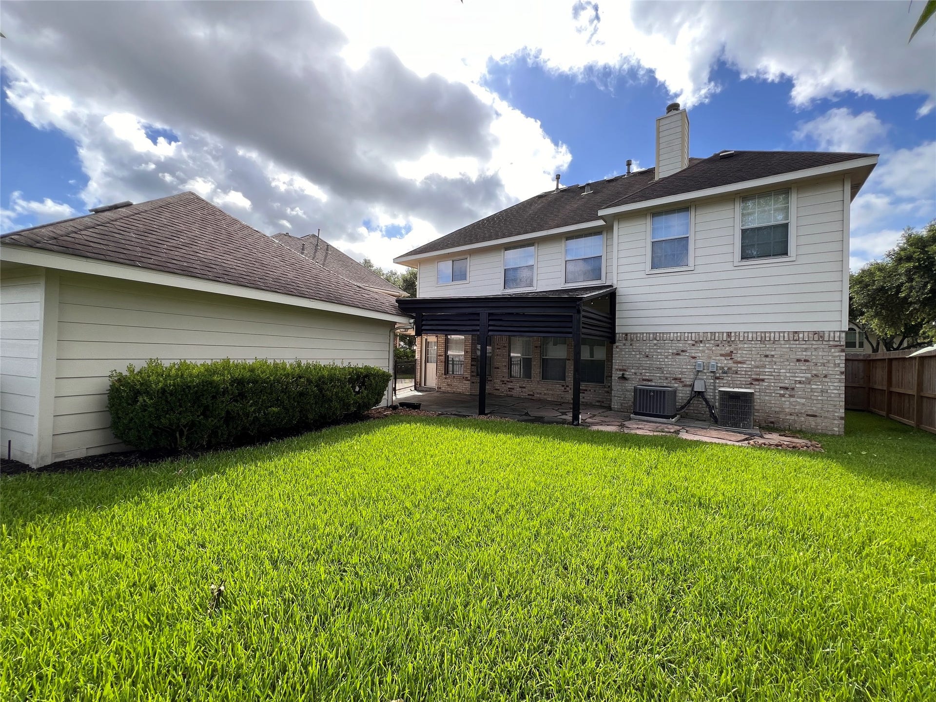 908 Azalea Pointe, League City, TX 77573 Experience serene outdoor living with this charming home's expansive backyard, featuring a covered patio perfect for relaxation and entertainment.