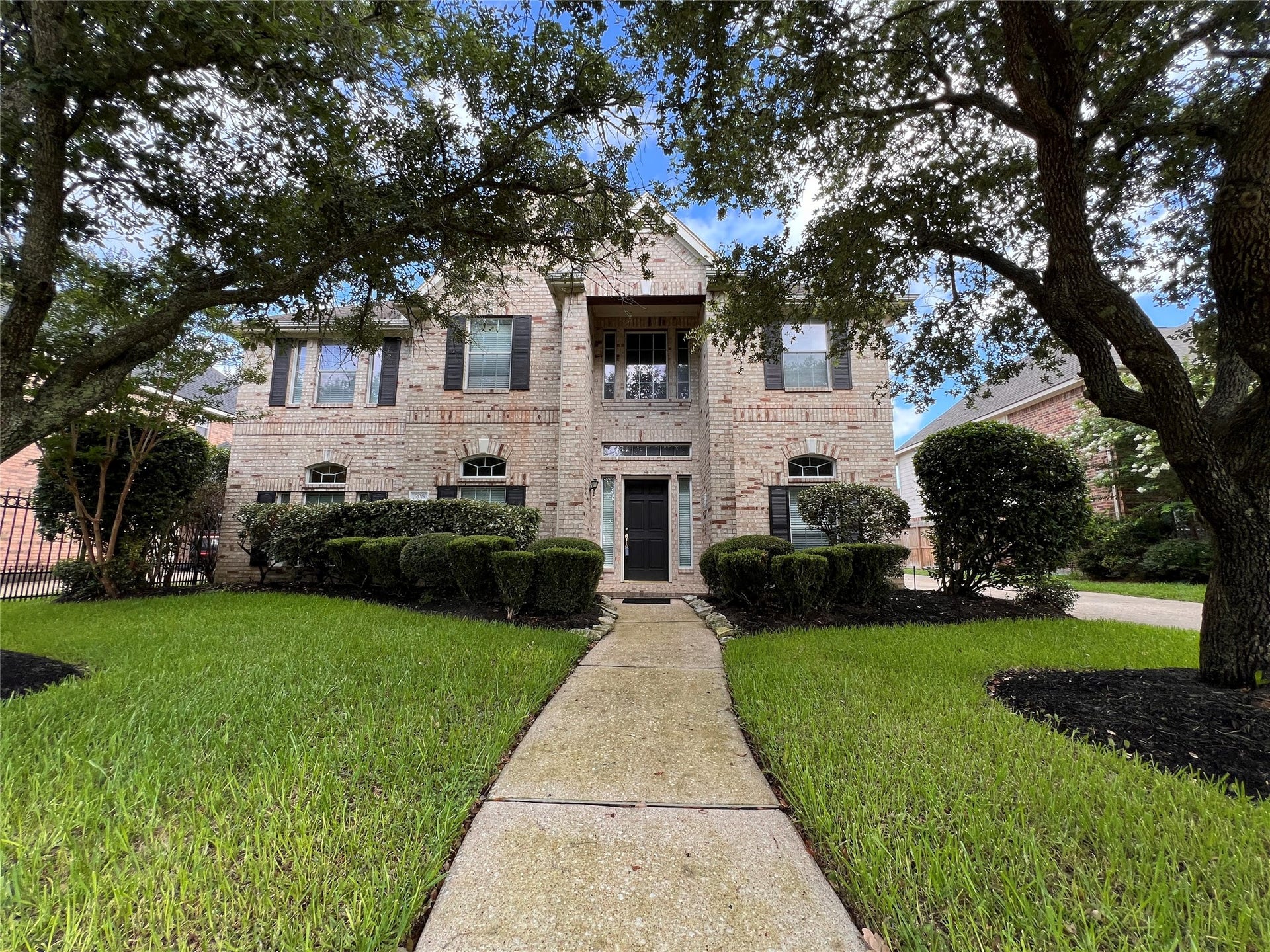 908 Azalea Pointe, League City, TX 77573 Discover timeless elegance in this stunning brick home, framed by mature trees and lush landscaping, offering a warm and inviting welcome.