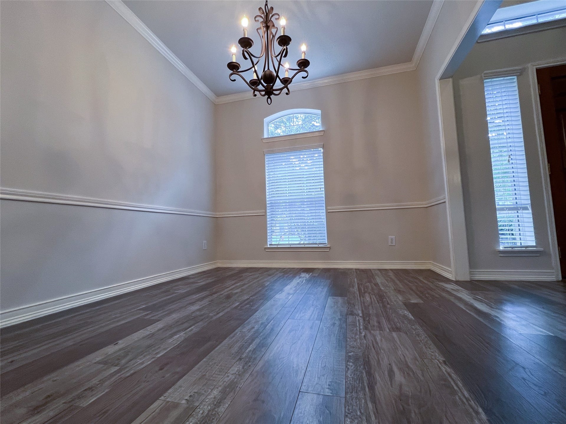 908 Azalea Pointe, League City, TX 77573 Experience elegant dining in this inviting room, featuring rich floors, a stylish chandelier, and abundant natural light through large windows.