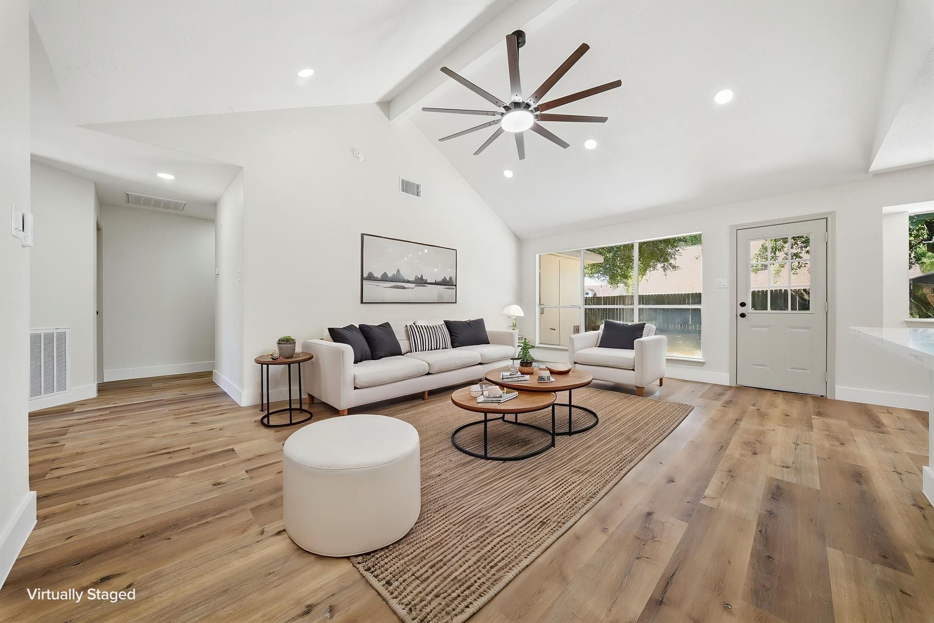 3816 Youpon Drive, La Porte, TX 77571 Bright and spacious living area featuring vaulted ceilings, a modern ceiling fan, and warm LVN flooring, seamlessly connecting to a large window and glass door for abundant natural light.