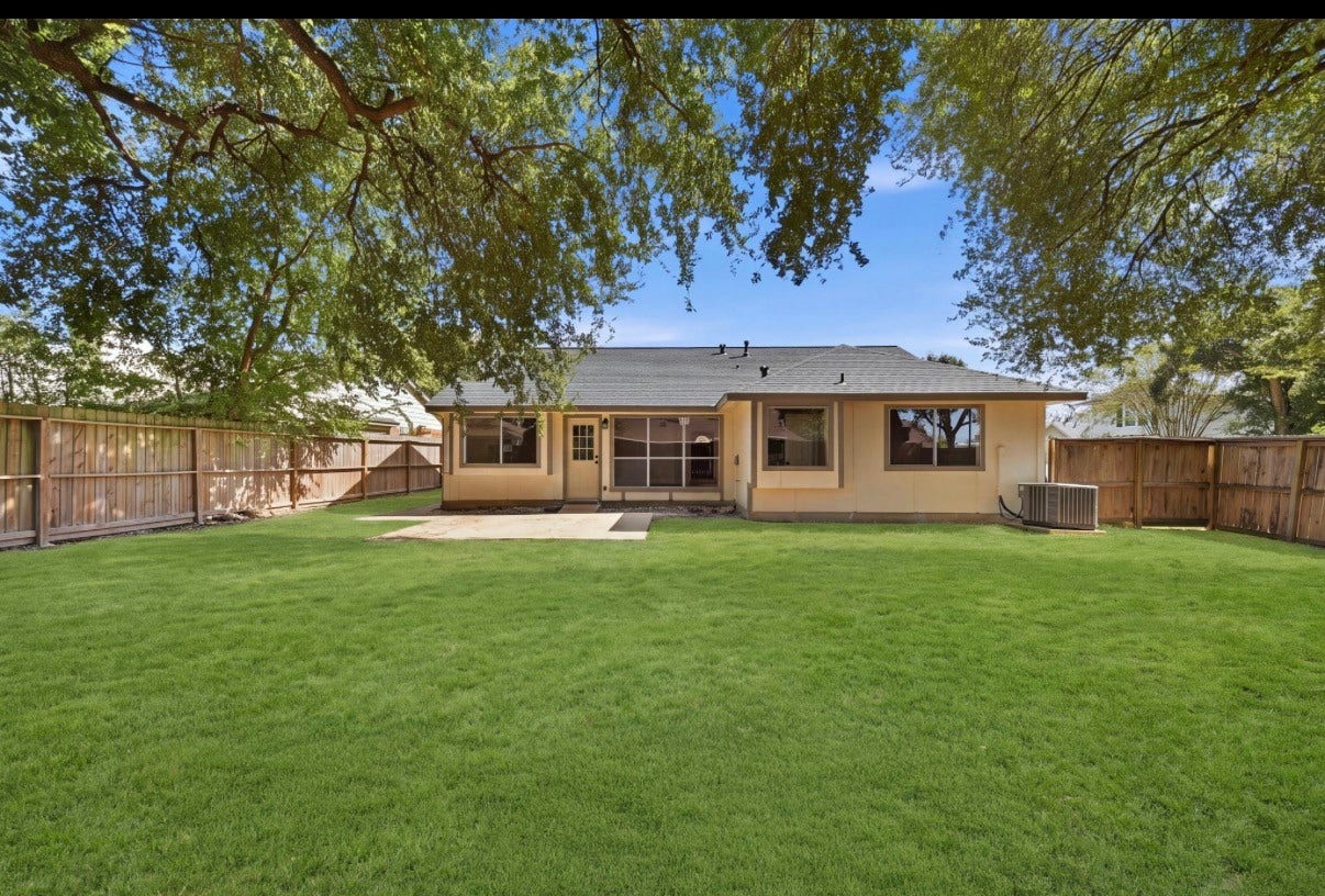 3816 Youpon Drive, La Porte, TX 77571 Charming backyard with lush green grass, a spacious patio for outdoor entertaining, and mature trees providing ample shade, all enclosed by wooden fence for privacy.