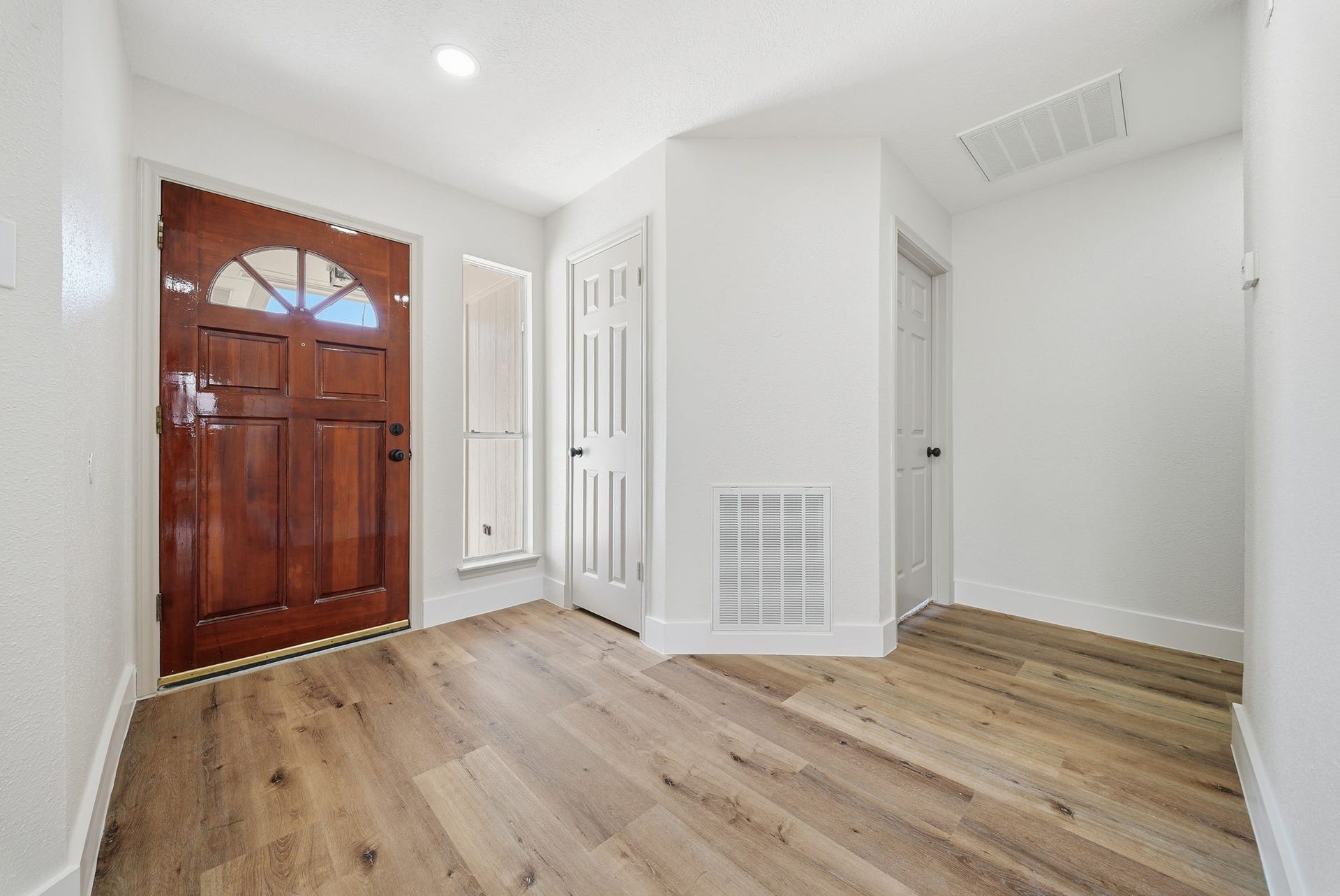 3816 Youpon Drive, La Porte, TX 77571 The entryway showcases a wood arch window front door, complemented by light-color walls and LVP flooring.
