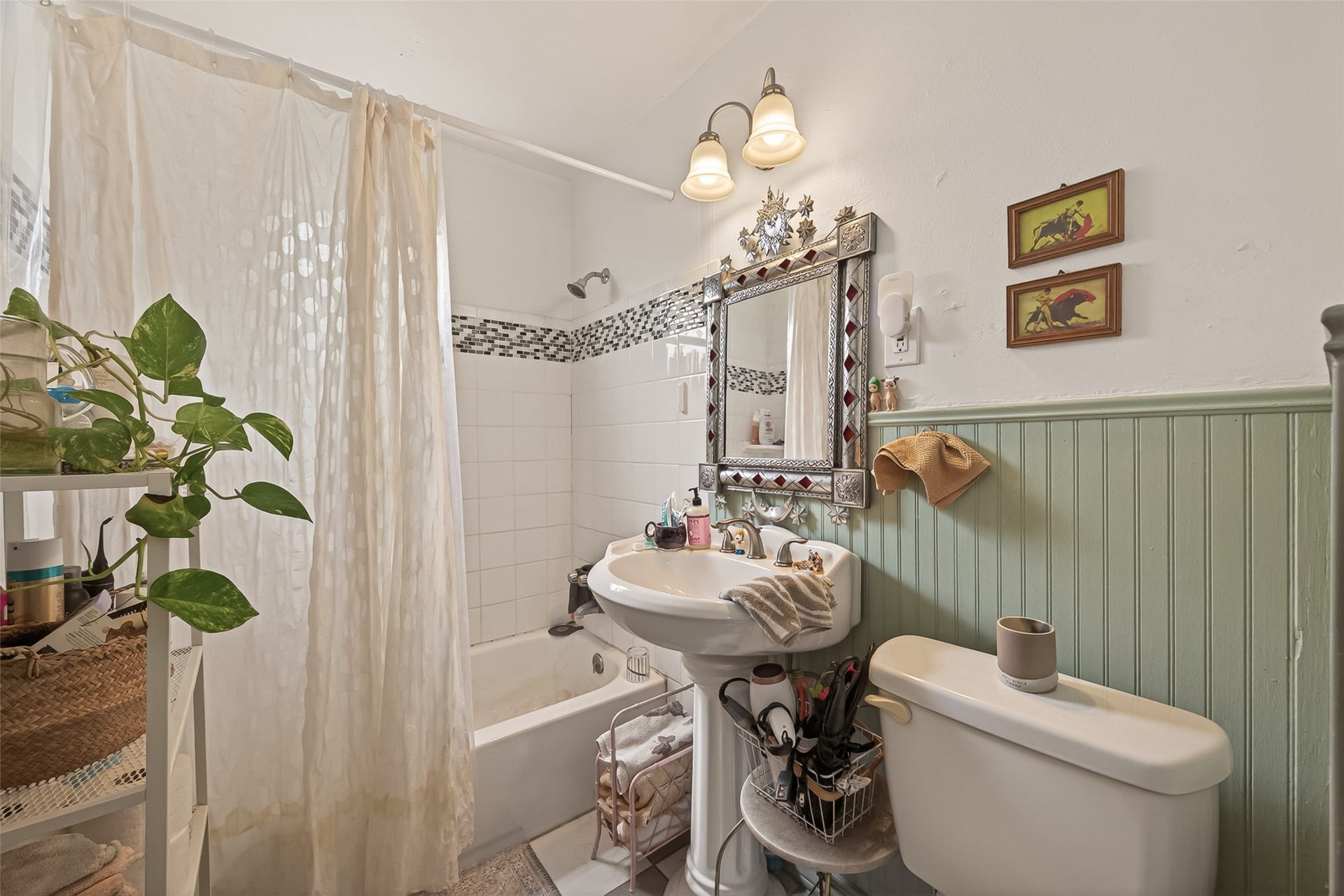 516 N Eastwood Street, Houston, TX 77011 The bathroom features a classic pedestal sink and a tub/shower combination.