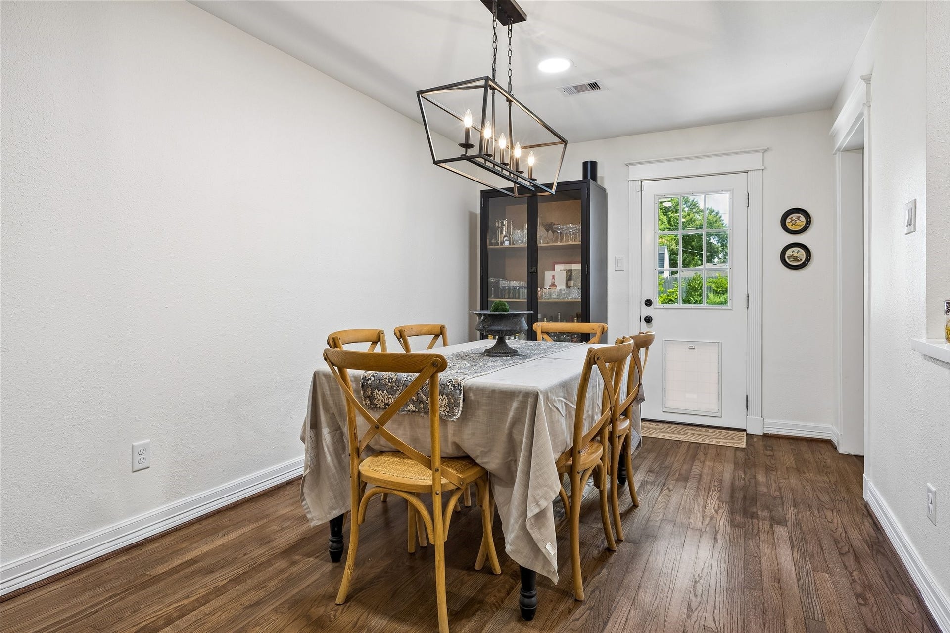 Charming dining area with a modern chandelier and warm hardwood floors. Doggie door to back yard ready for your pets!