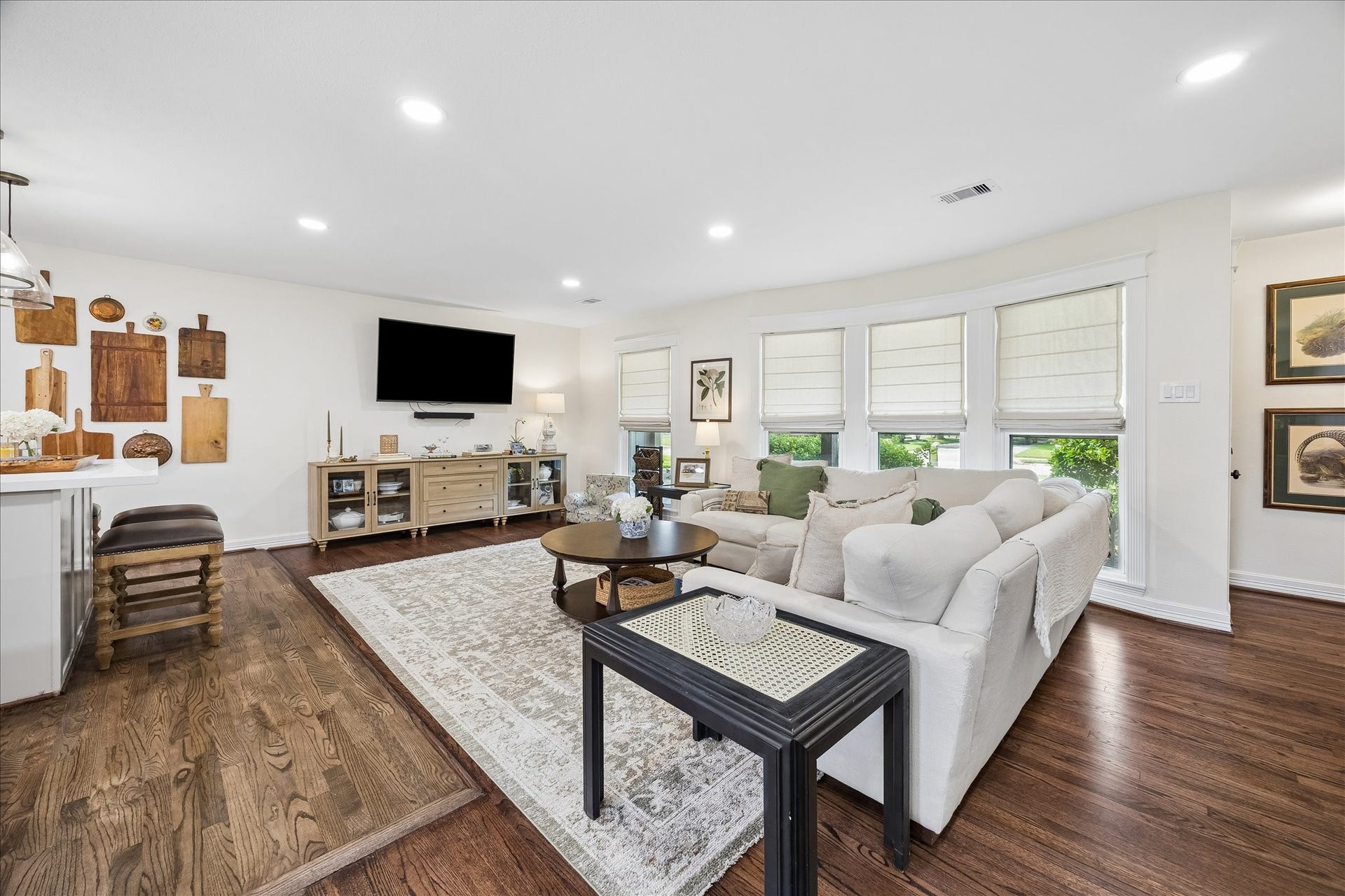 Bright and inviting living area. Recessed LED can lights, hardwood floors, all bathed in natural light from multiple windows.