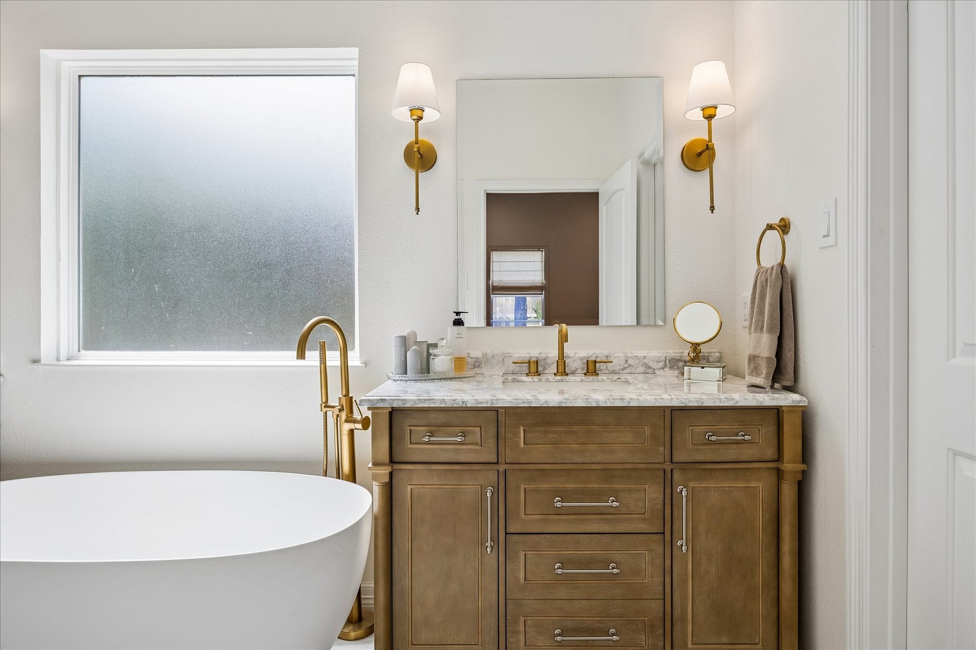 Gold accent lighting and plumbing fixtures at both vanities.