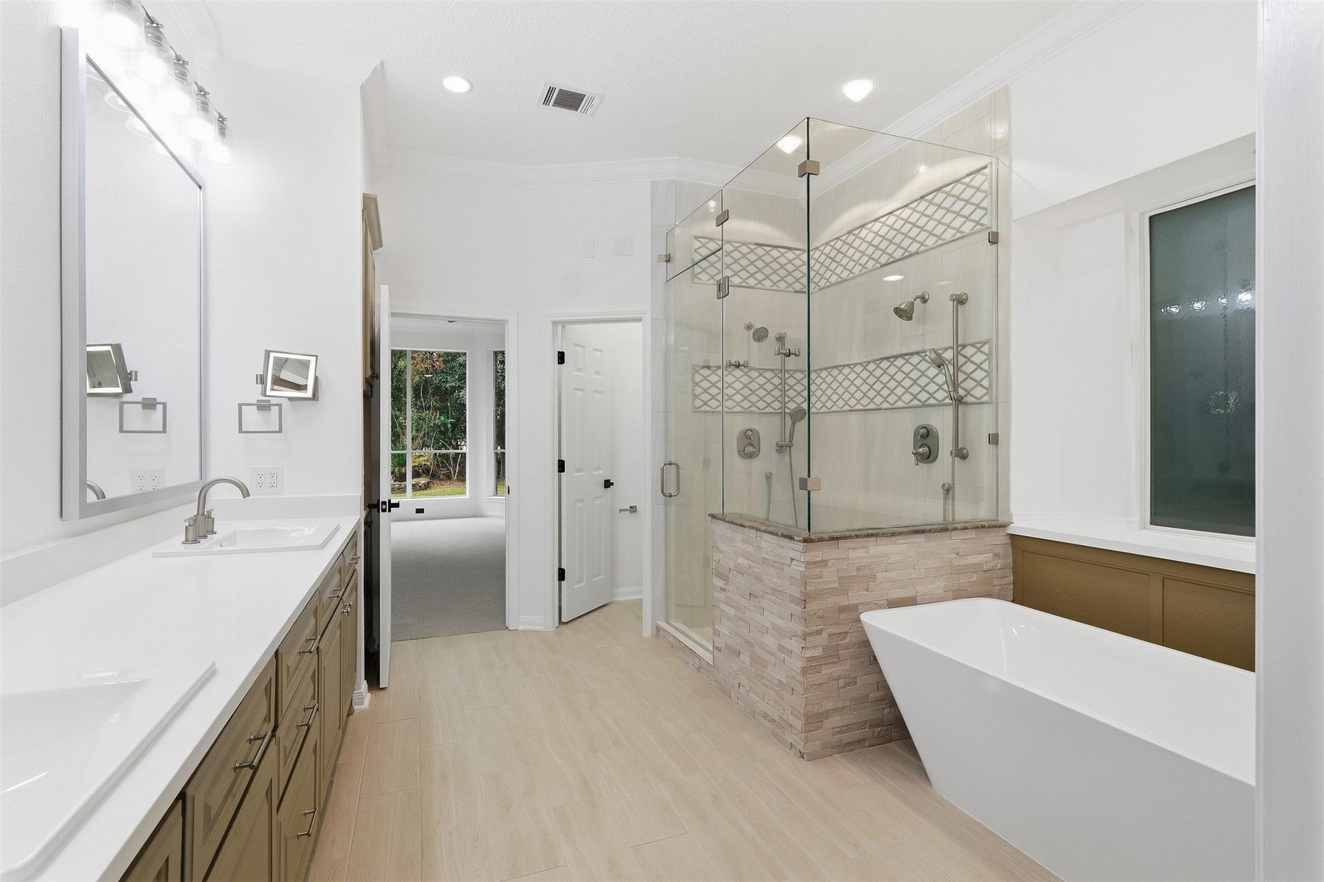 Primary bath features a relaxing soaker tub and an oversized walk-in shower with dual showerheads and a hand sprayer.