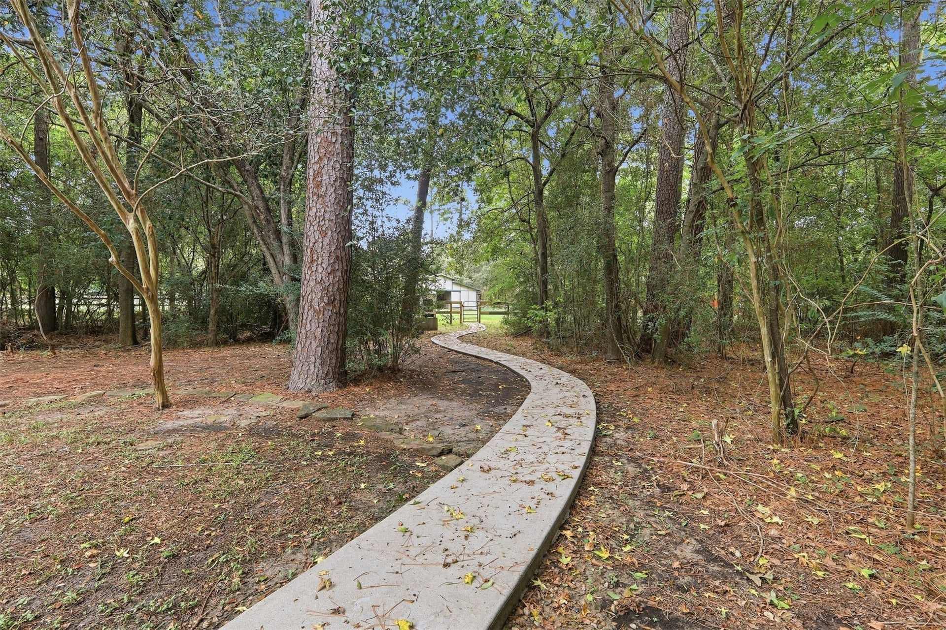 This winding path draws you deeper into the property toward the corrals, barn, riding arena and more open land.