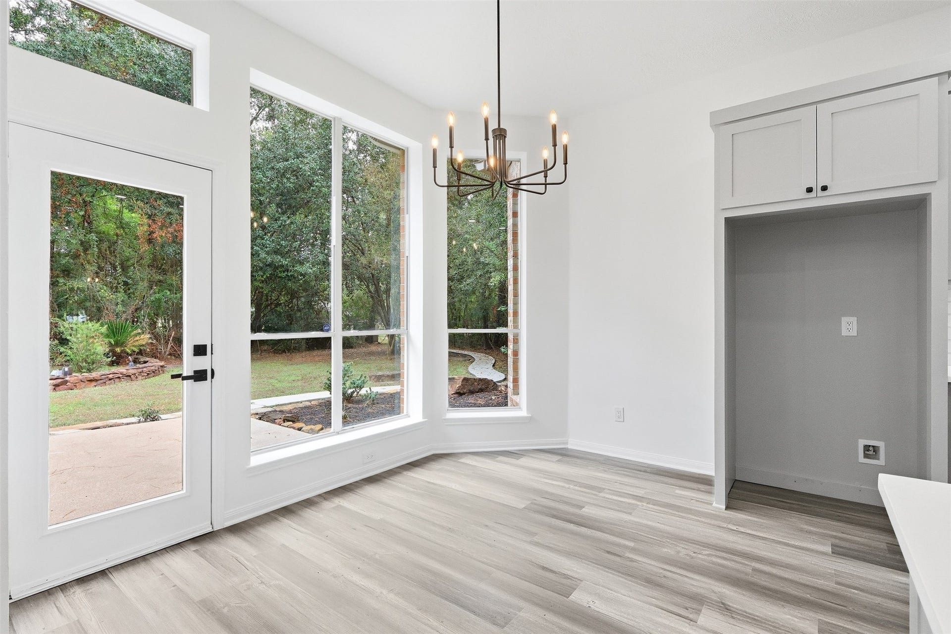 Breakfast nook overlooks the peaceful, tranquil backyard, framed by floor-to-ceiling windows.