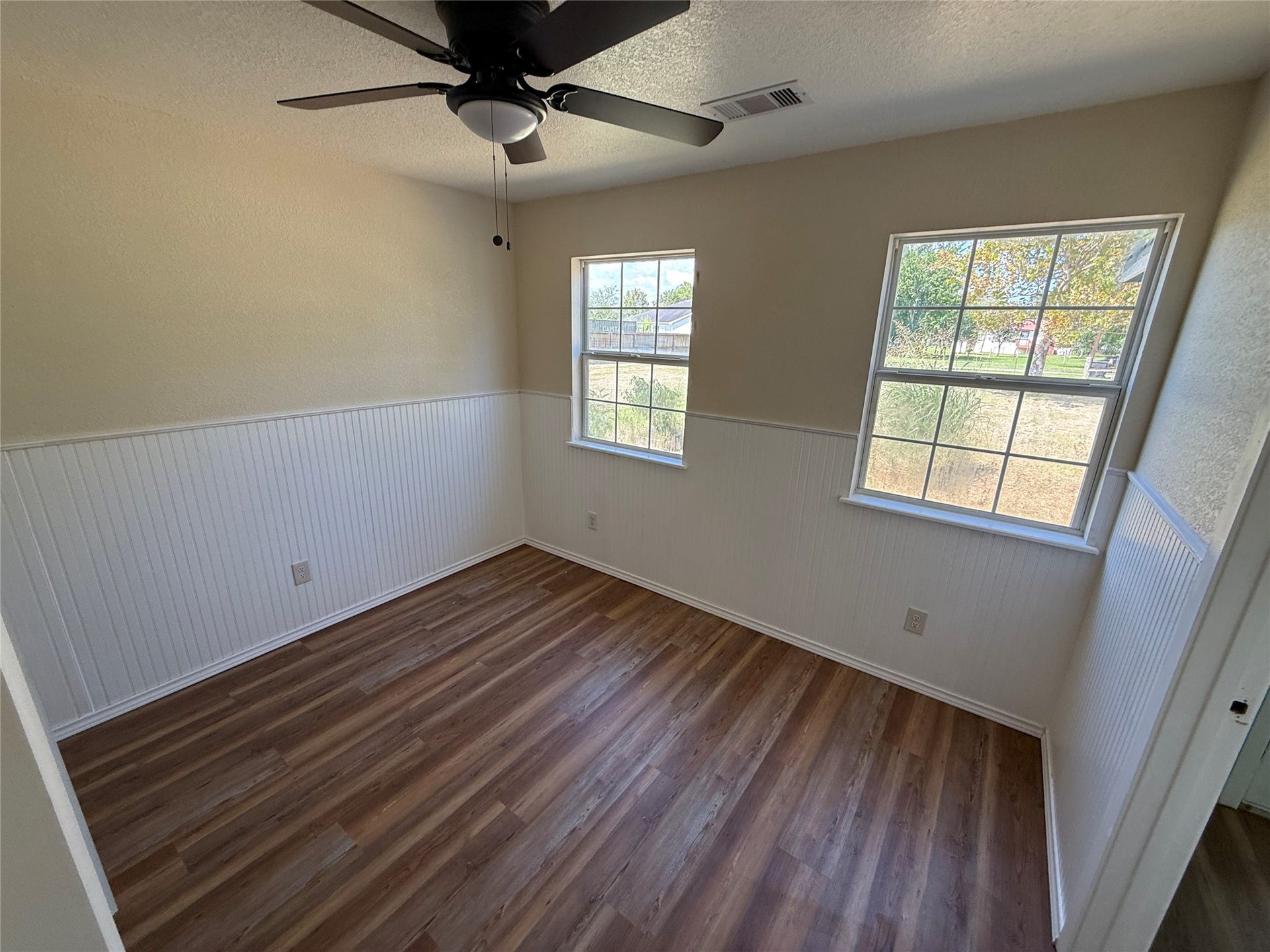 2524 Shouse Road, Santa Fe, TX 77510 Corner room with multiple windows, wood-look flooring, and a ceiling fan.