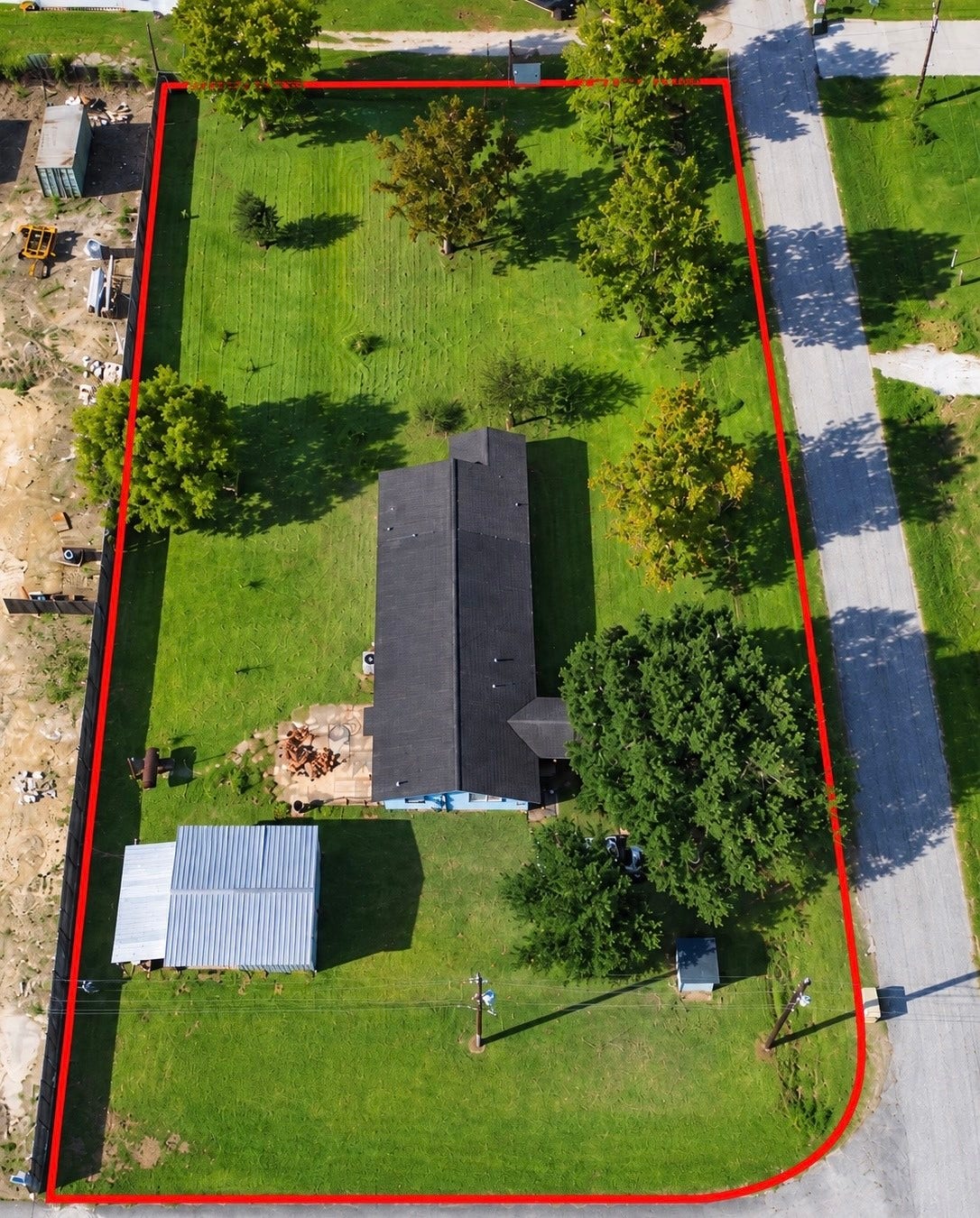 2524 Shouse Road, Santa Fe, TX 77510 Aerial view showcasing the spacious green lawn, mature trees, home, and detached outbuilding. Approximate property boundary outlined in red for reference.