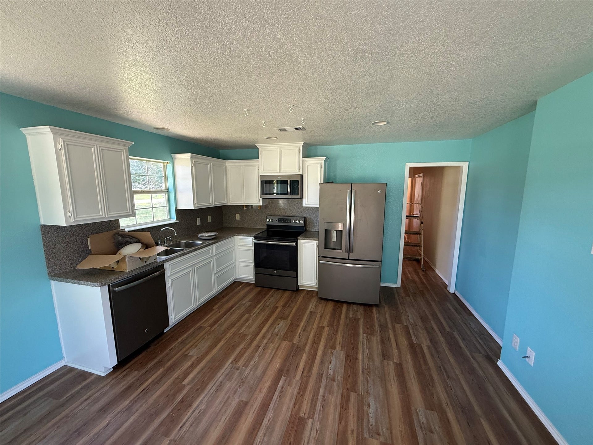 2524 Shouse Road, Santa Fe, TX 77510 Spacious kitchen with white cabinetry, stainless steel appliances, and wood-look flooring.