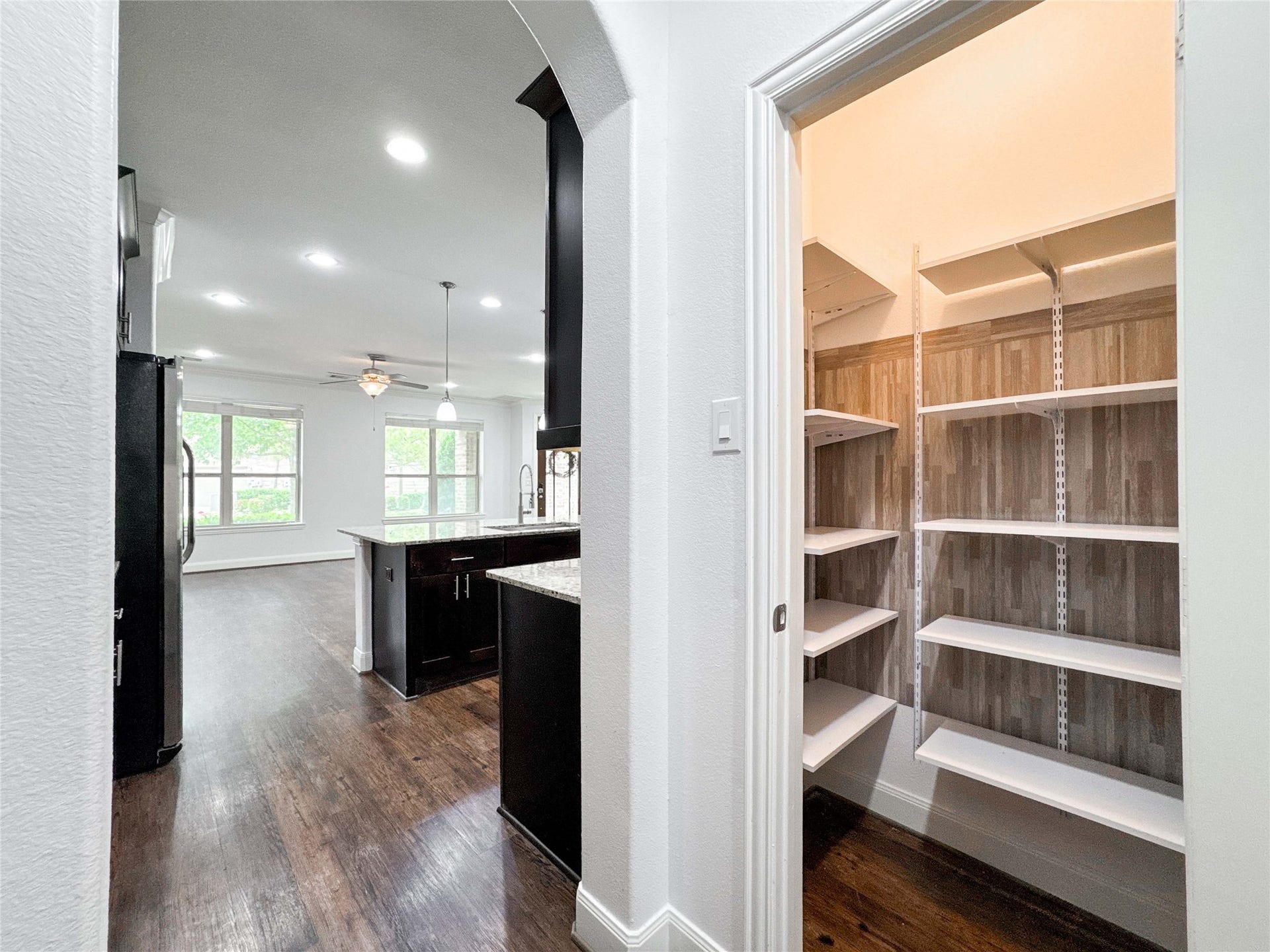 Alternate view of the mudroom offers a peek into the walk-in pantryshowcasing smart, seamless flow and functional design.