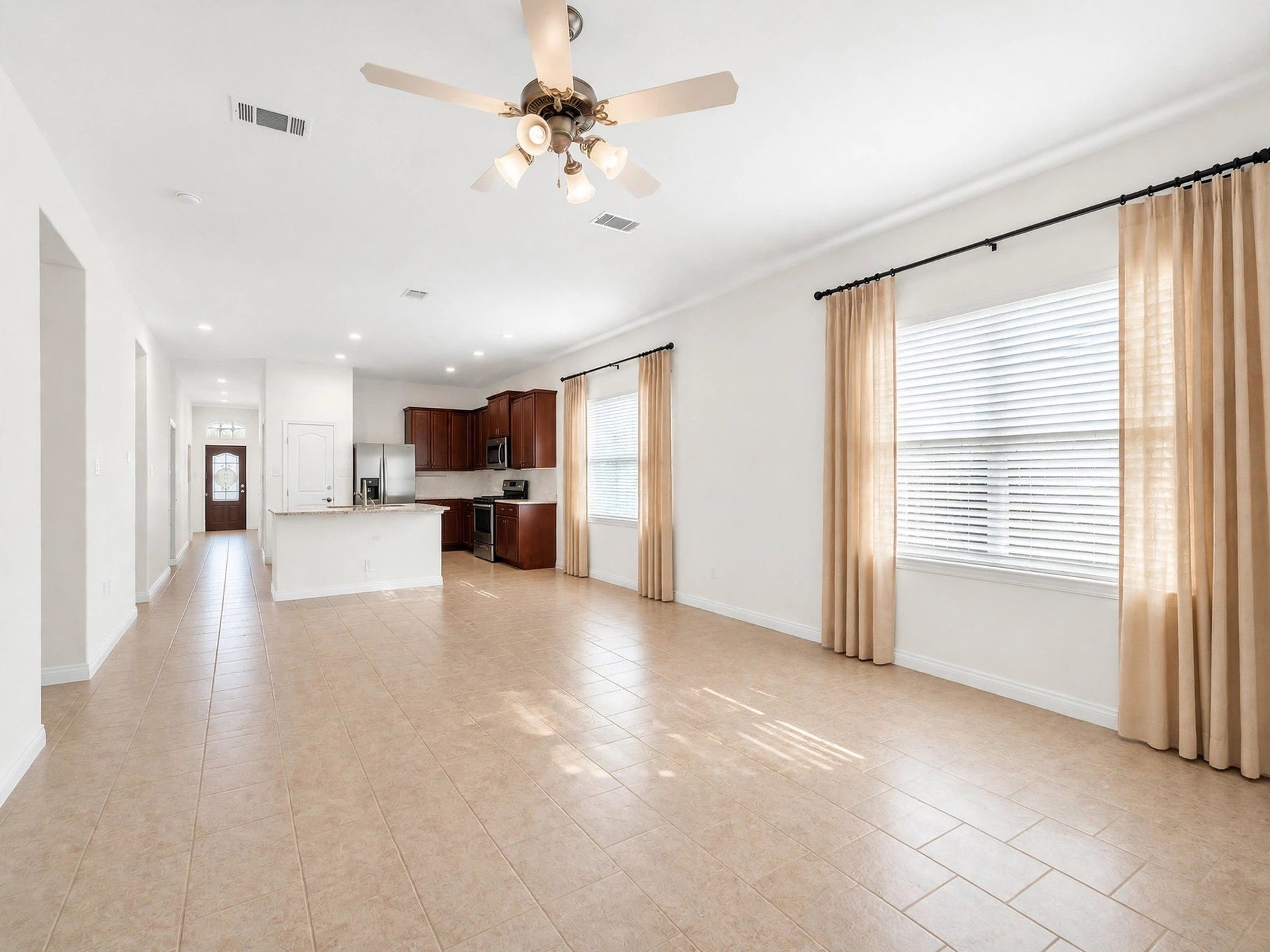 1902 Willow Ridge Lane, Fulshear, TX 77423 Unfurnished view of the living area highlights the tile flooring, large windows, and open kitchen connection.