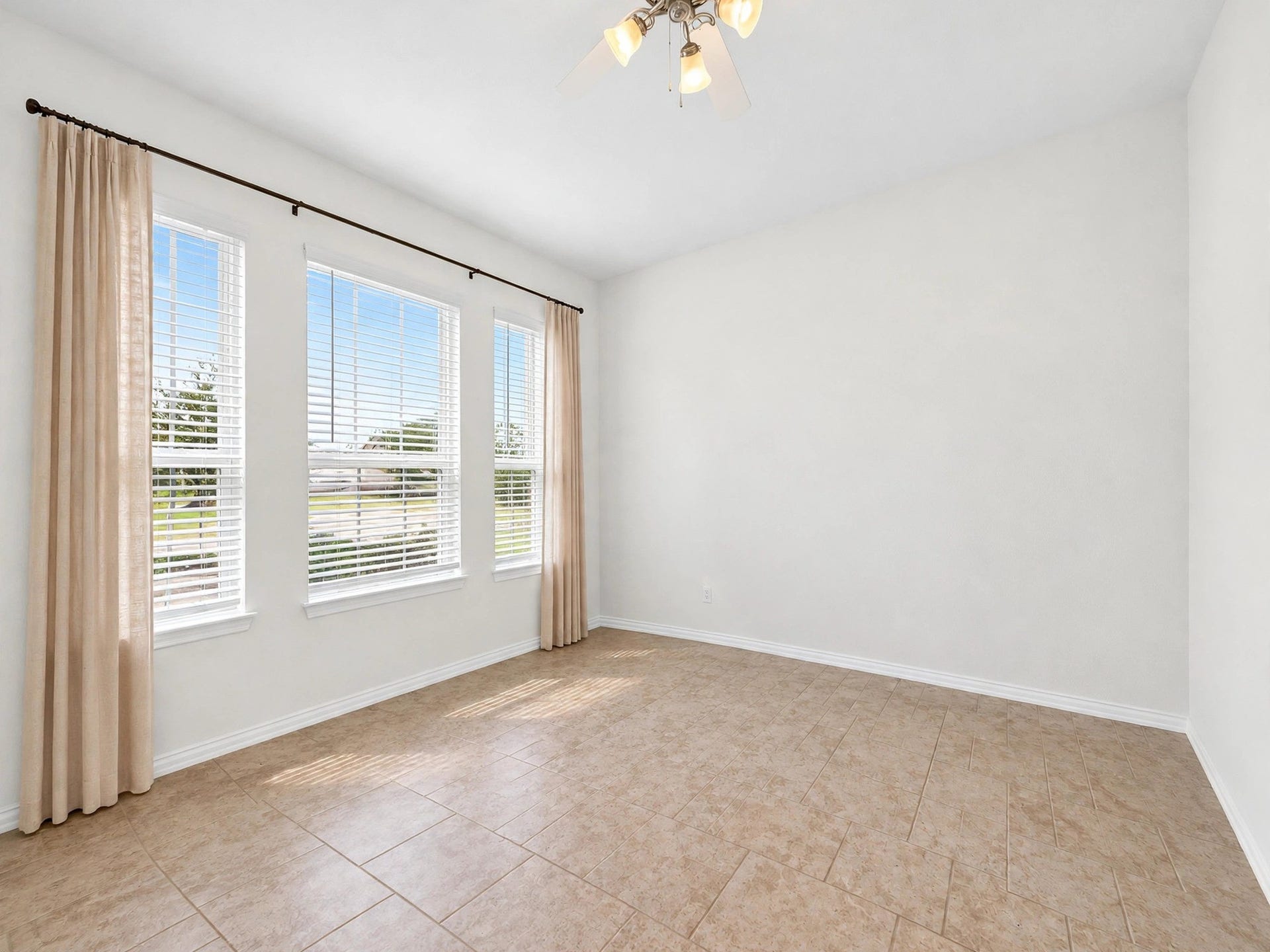 1902 Willow Ridge Lane, Fulshear, TX 77423 Unfurnished view highlights this rooms tile flooring, large windows, and flexible layout.