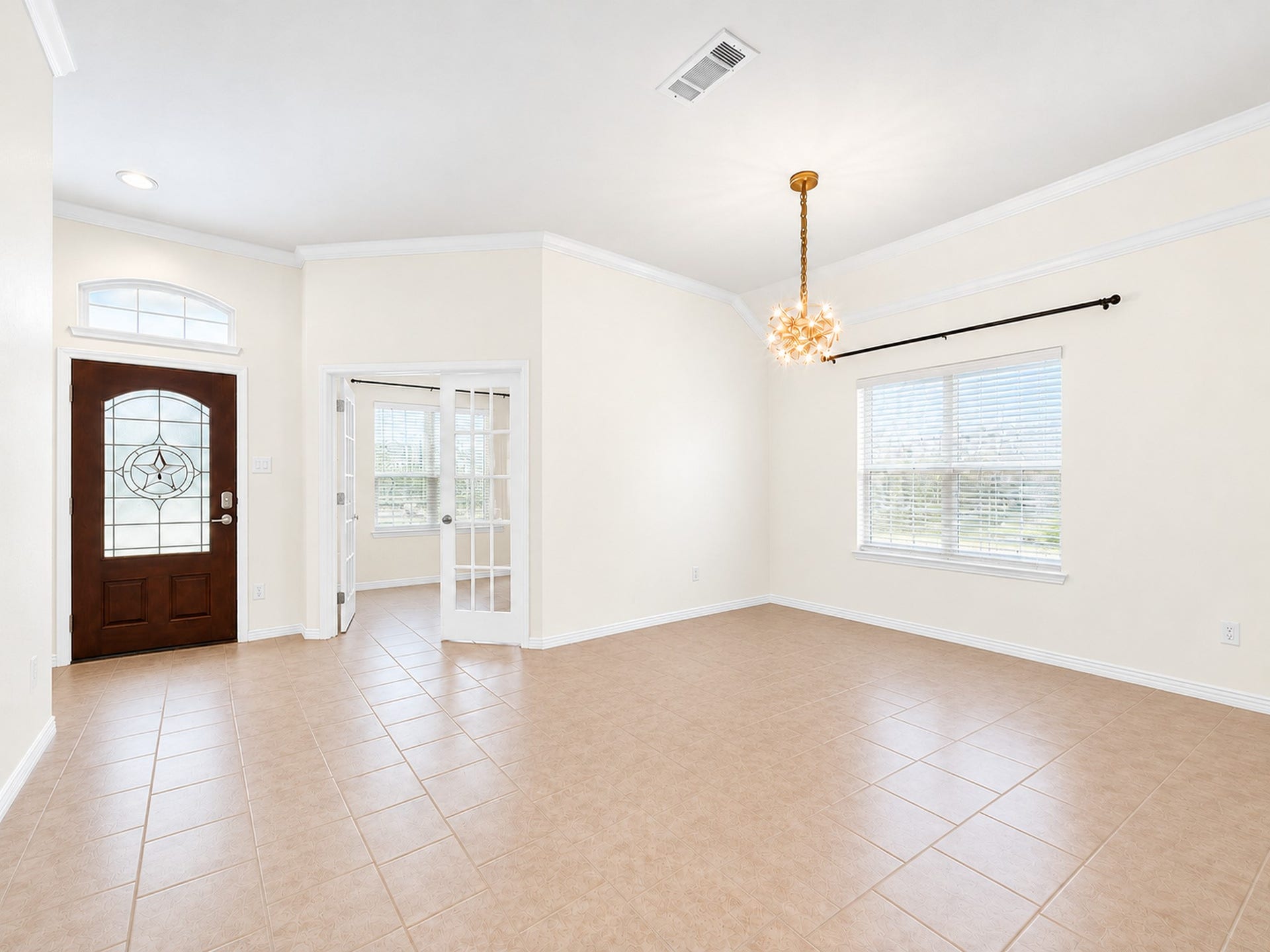 1902 Willow Ridge Lane, Fulshear, TX 77423 Furniture and personal dcor have been digitally removed to showcase the dining rooms layout, tile flooring, crown molding, and natural light. French doors connect to an adjacent room near the front entry.