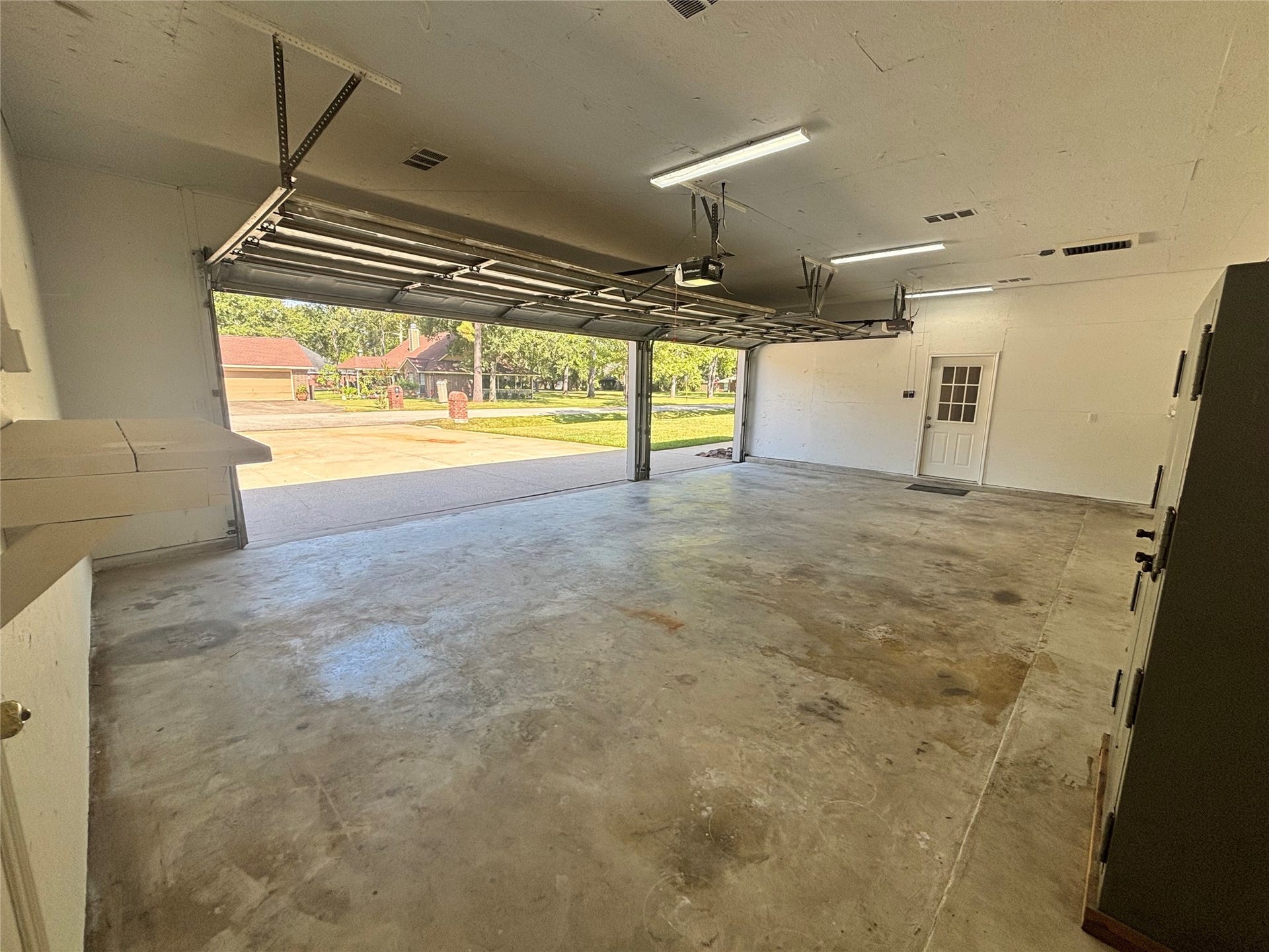 1125 W Stroker Road, #1125, Crosby, TX 77532 Large 3 car attached garage with high ceilings.