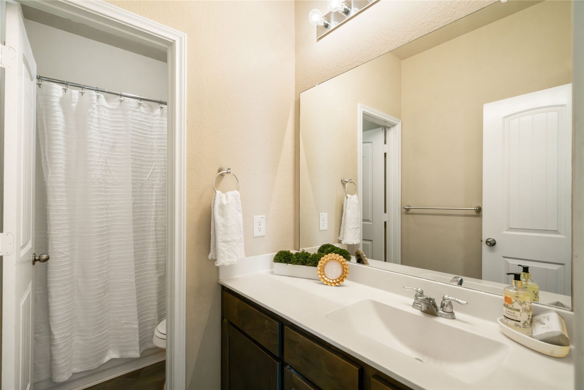 Convenient secondary bath featuring a spacious vanity, oversized mirror, and separate tub/shower area for added functionality and privacy.