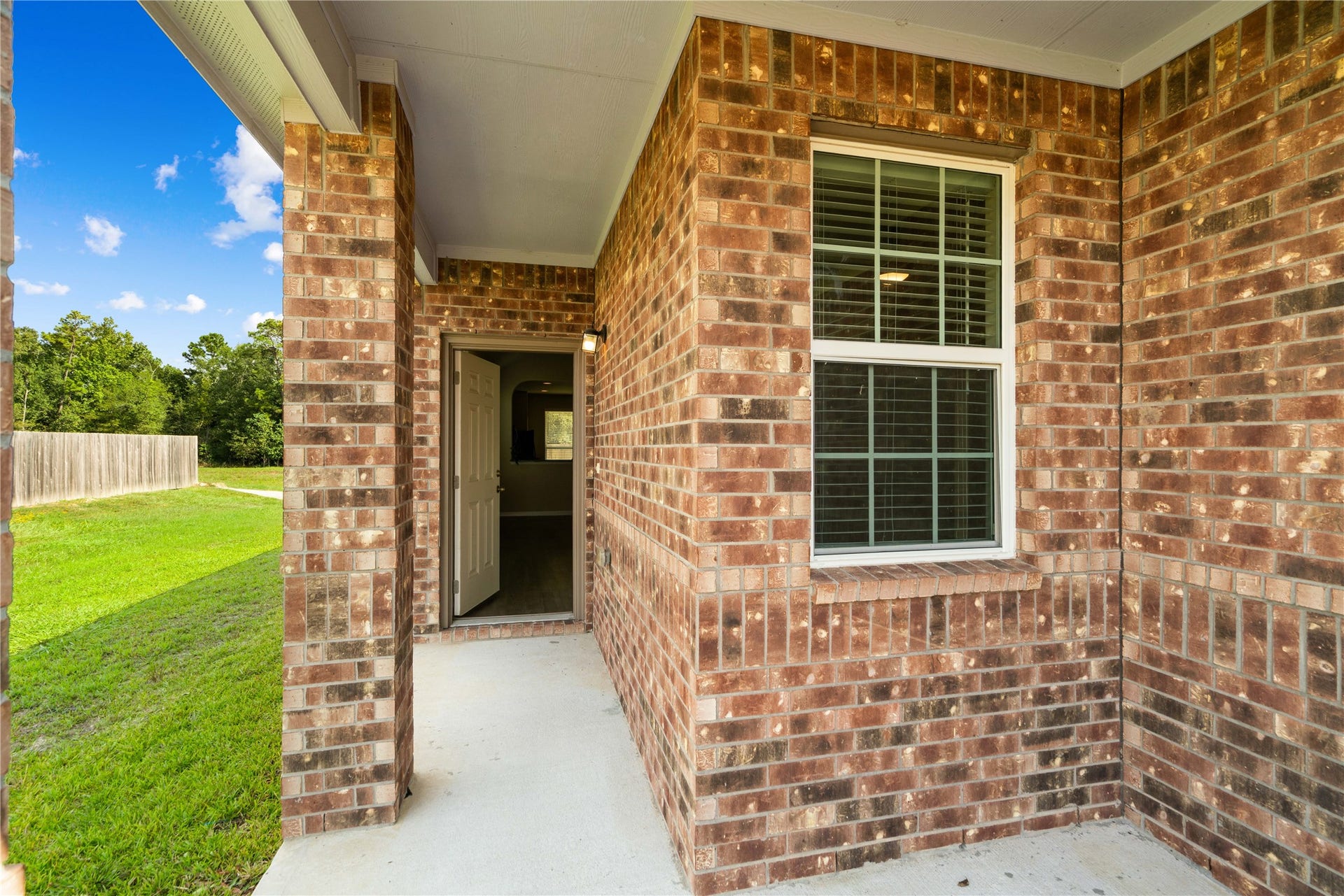 A welcoming covered front porch framed by classic brickwork creates an inviting entry and offers a cozy spot for a bench or your favorite assortment of plants.