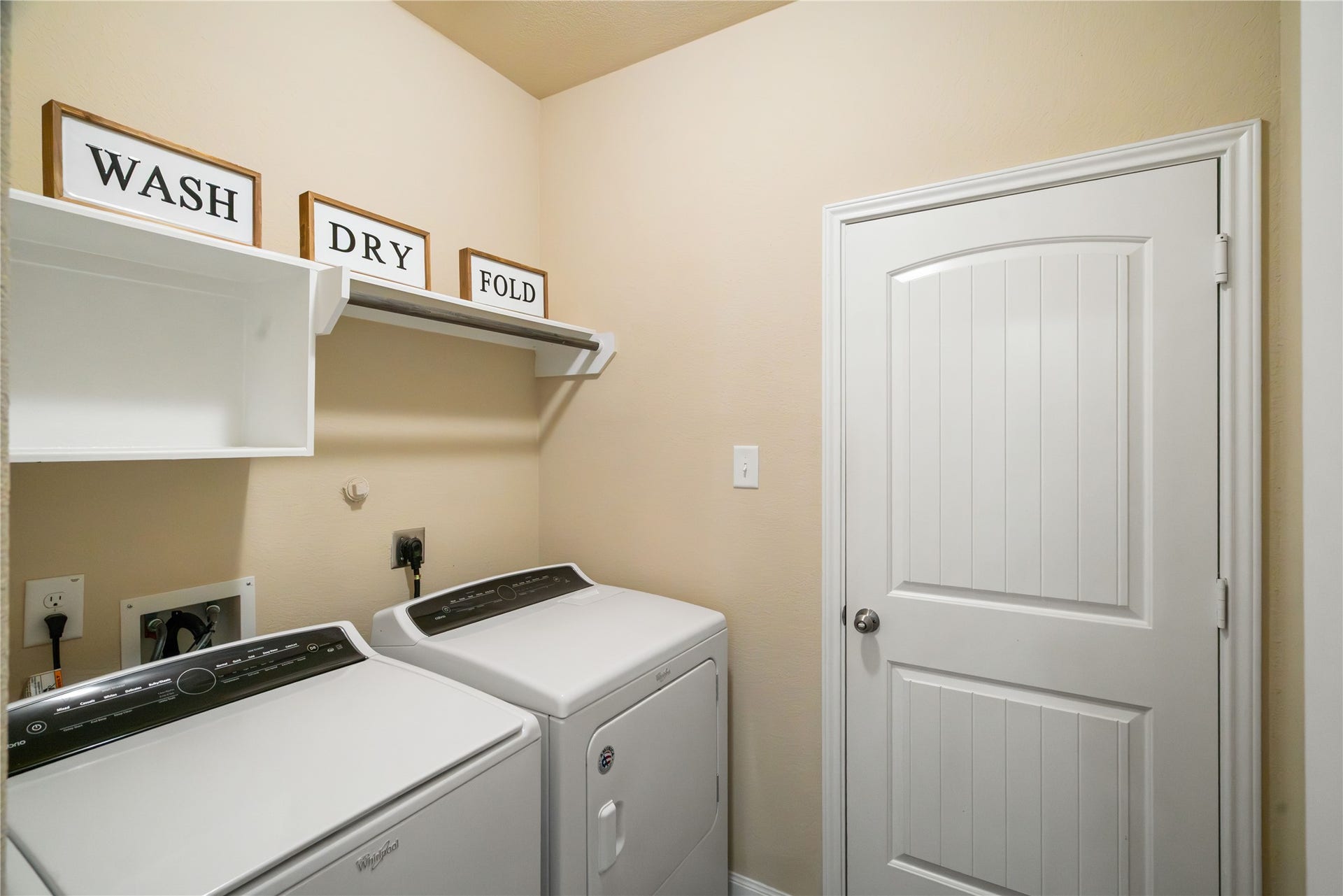Convenient indoor utility room with built-in shelving and direct access to the garage, making everyday routines easy and efficient.